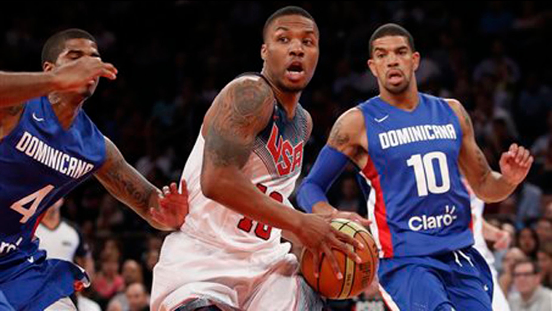 Dominican Republic guards Edgar Sosa (4) and James Feldeine (10) defend as United States guard Kyrie Irving (10) looks to pass while heading toward the basket in the first half of an exhibition basketball game at Madison Square Garden in New York, Wednesday, Aug. 20, 2014. (AP Photo/Kathy Willens)