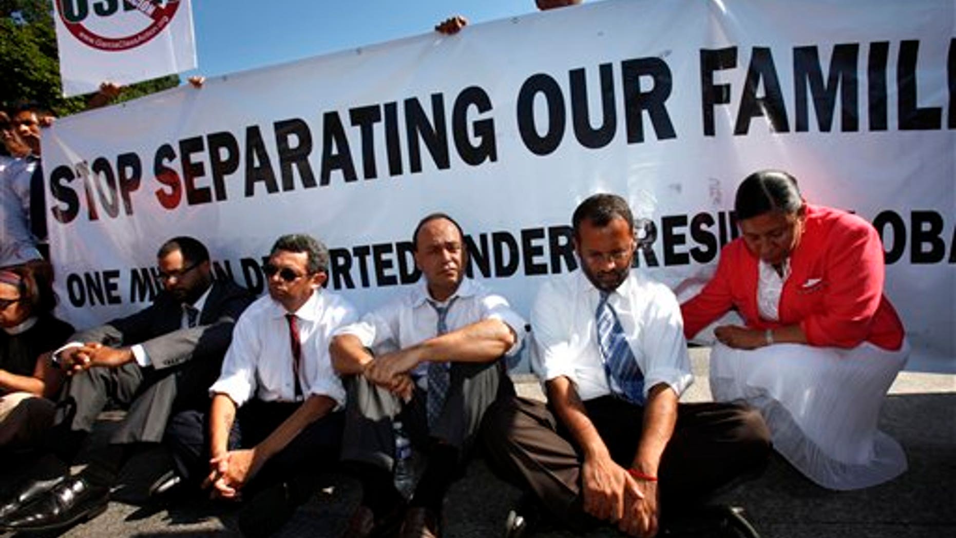 July 26: Supporters of the DREAM Act, including Rep. Luis Gutierrez, D-Ill., third from right, wait to be arrested while performing an act of civil disobedience at a rally for supporting the DREAM Act and immigration reform outside the White House in Washington, D.C.