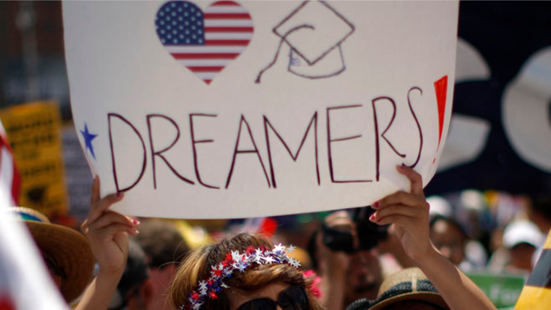 FILE: May 1, 2013: A Dream Act supporter carries a sign during the International Workers Day and Immigration Reform March in Los Angeles, Calif.