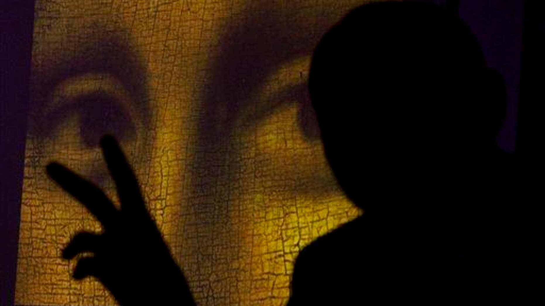 This 2011 file photo shows art historian and researcher Silvano Vinceti, silhouetted, gesturing as an image showing the detail of the eyes of Italian artist Leonardo da Vinci's "Mona Lisa" painting is projected.