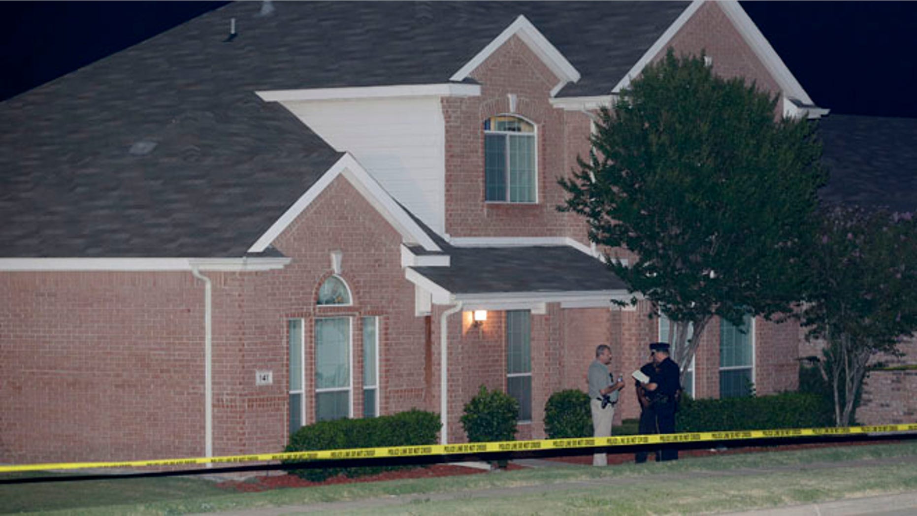 Aug. 8: Law enforcement officers confer outside the house of a fatal shooting in DeSoto, Texas.