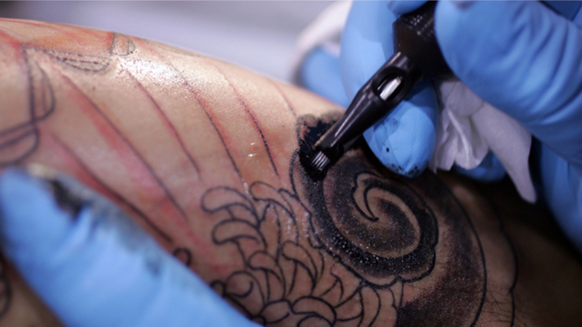 FILE - This Jsn. 6, 2006, file photo shows a tattoo artist from Los Angels during the Body Art Expo at the Los Angeles county fairgrounds in Pomona, Calif. (AP Photo/Chris Carlson, File)