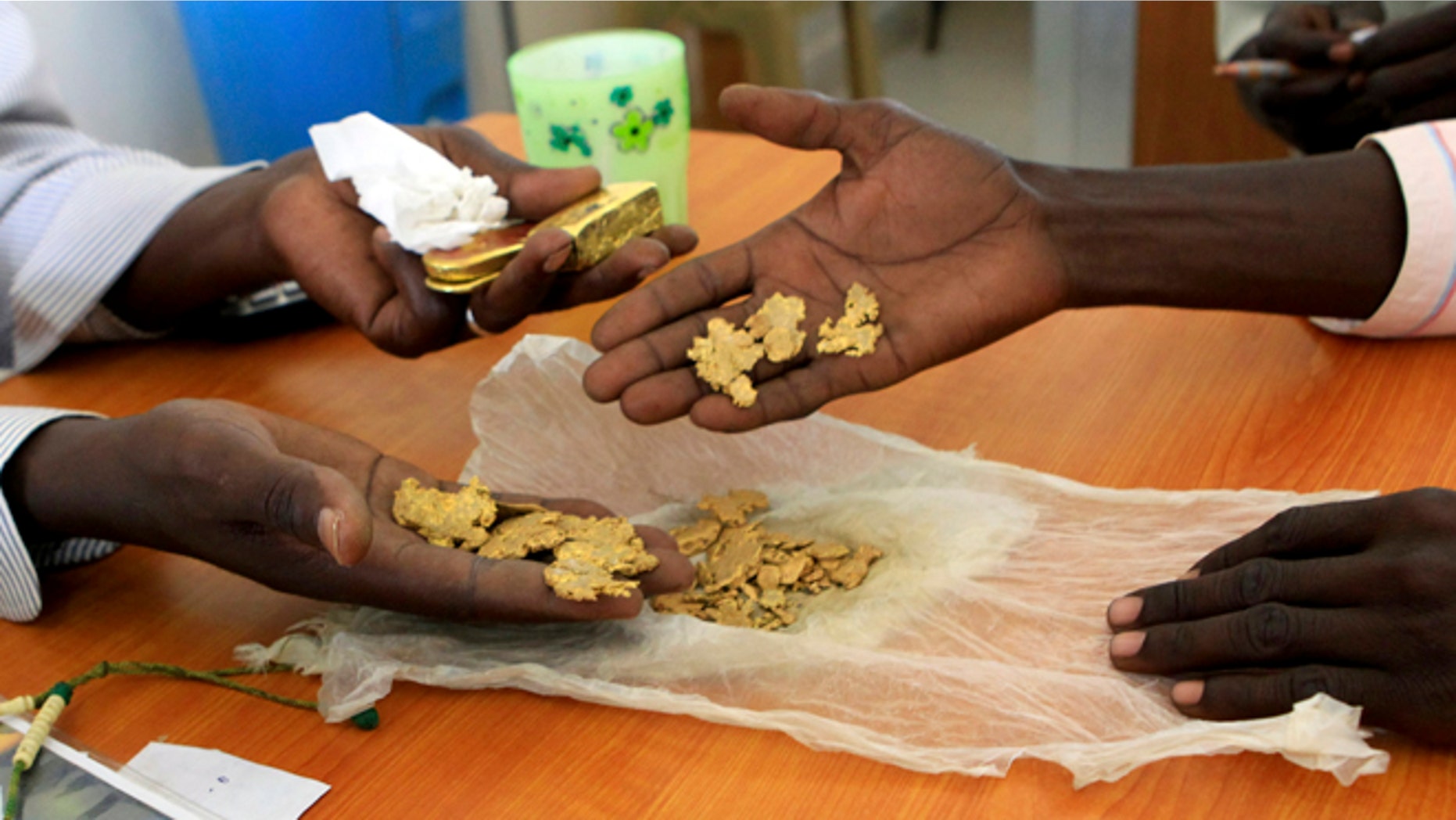 September 24, 2013: Gold mine workers wait to get their raw gold weighed at a gold shop in the town of Al-Fahir in North Darfur.