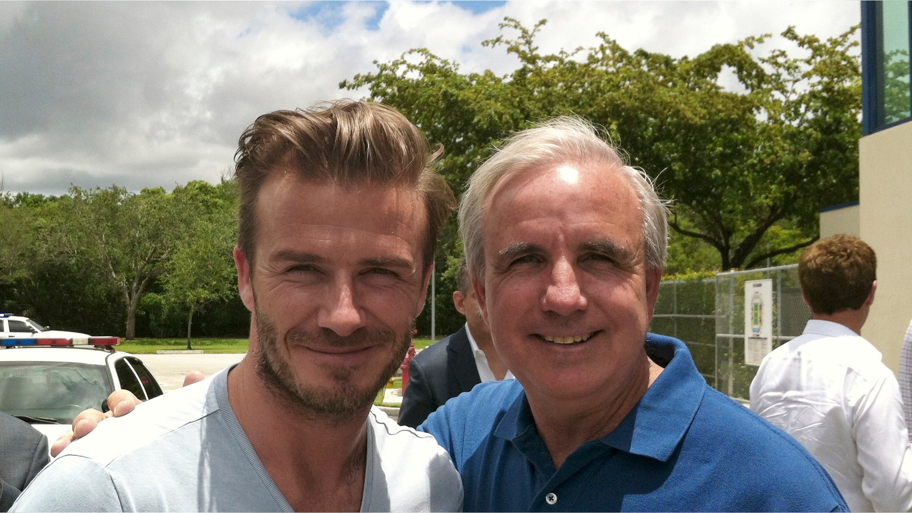 In this undated photo released by Miami-Dade County, former soccer star David Beckham poses for a photo with Miami-Dade County Mayor Carlos Gimenez, in Miami. Beckham may be setting his sights on a new sports venture: A professional soccer team in Miami. The newly retired Beckham toured Sun Life and Florida International University stadiums and met with Miami-Dade County Mayor Carlos Gimenez on Saturday. (AP Photo/Miami-Dade County)