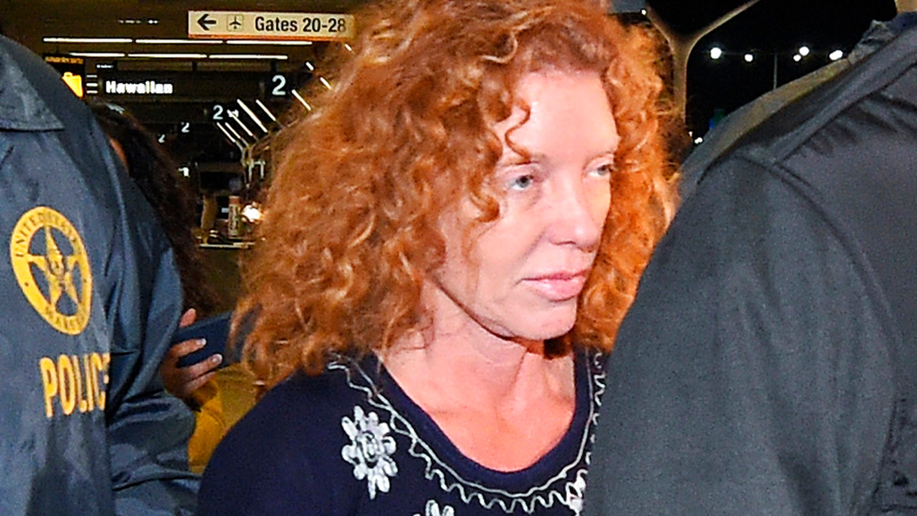 Tonya Couch, center, is taken by authorities to a waiting car after arriving at Los Angeles International Airport, Thursday, Dec. 31, 2015, in Los Angeles. Authorities said she and her son, Texas teenager Ethan Couch, who was sentenced to probation after using an "affluenza" defense for a 2013 wreck in Texas, fled to Mexico together in November as prosecutors investigated whether he had violated his probation. Both were taken into custody Monday, Dec. 28, after authorities said a phone call for pizza led to their capture in the resort city of Puerto Vallarta. (AP Photo/Mark J. Terrill)