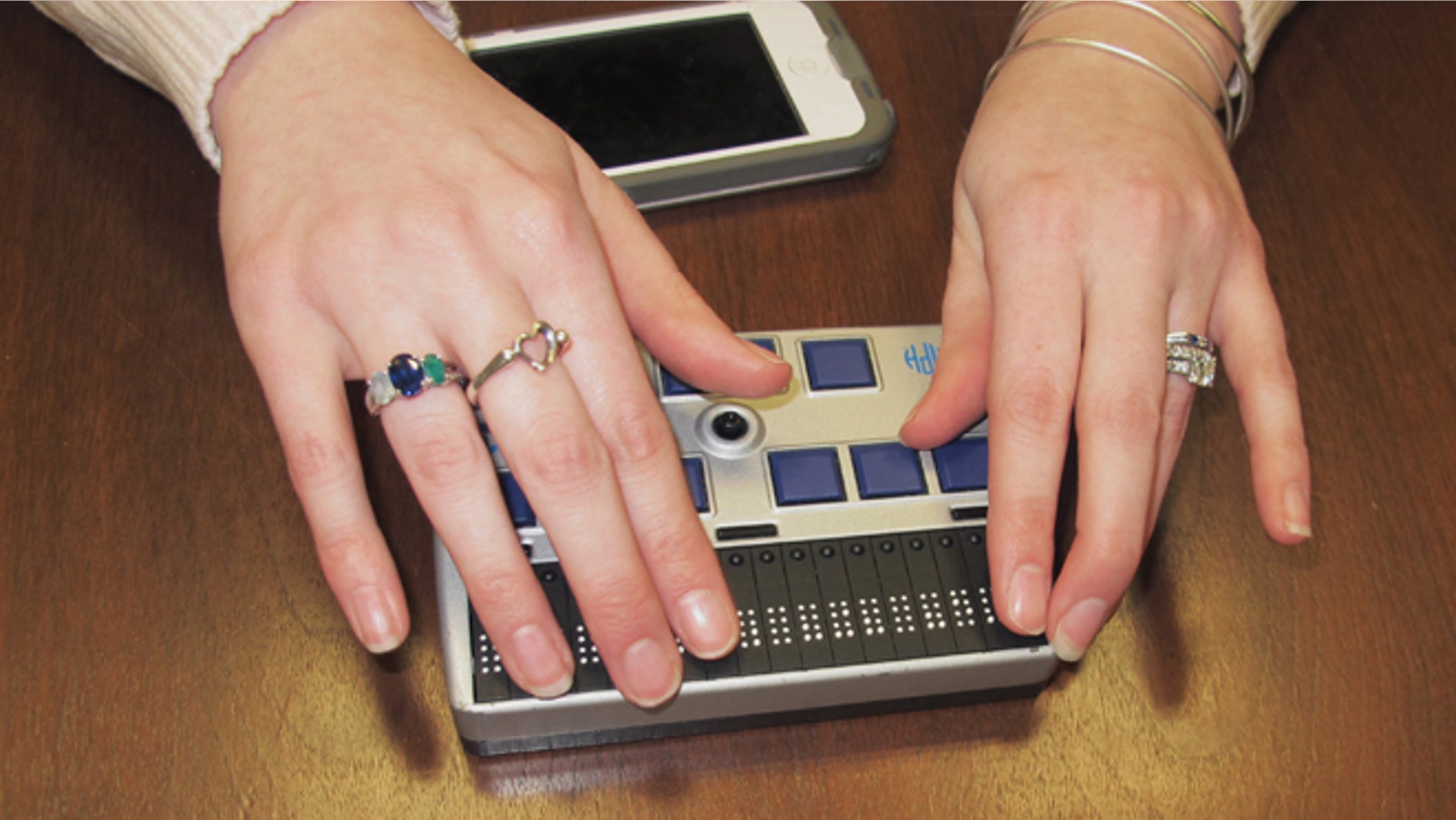 In this Wednesday, March 26, 2014 photo, Megan Dausch, an instructor at the Helen Keller National Center, demonstrates the use of a Braille reader that helps blind clients access the Internet, in Sands Point, N.Y. The center, based in suburban New York, is leading an effort to distribute $10 million annually in high-technology equipment to assist low-income deaf and blind consumers across the country. (AP Photo/Frank Eltman)