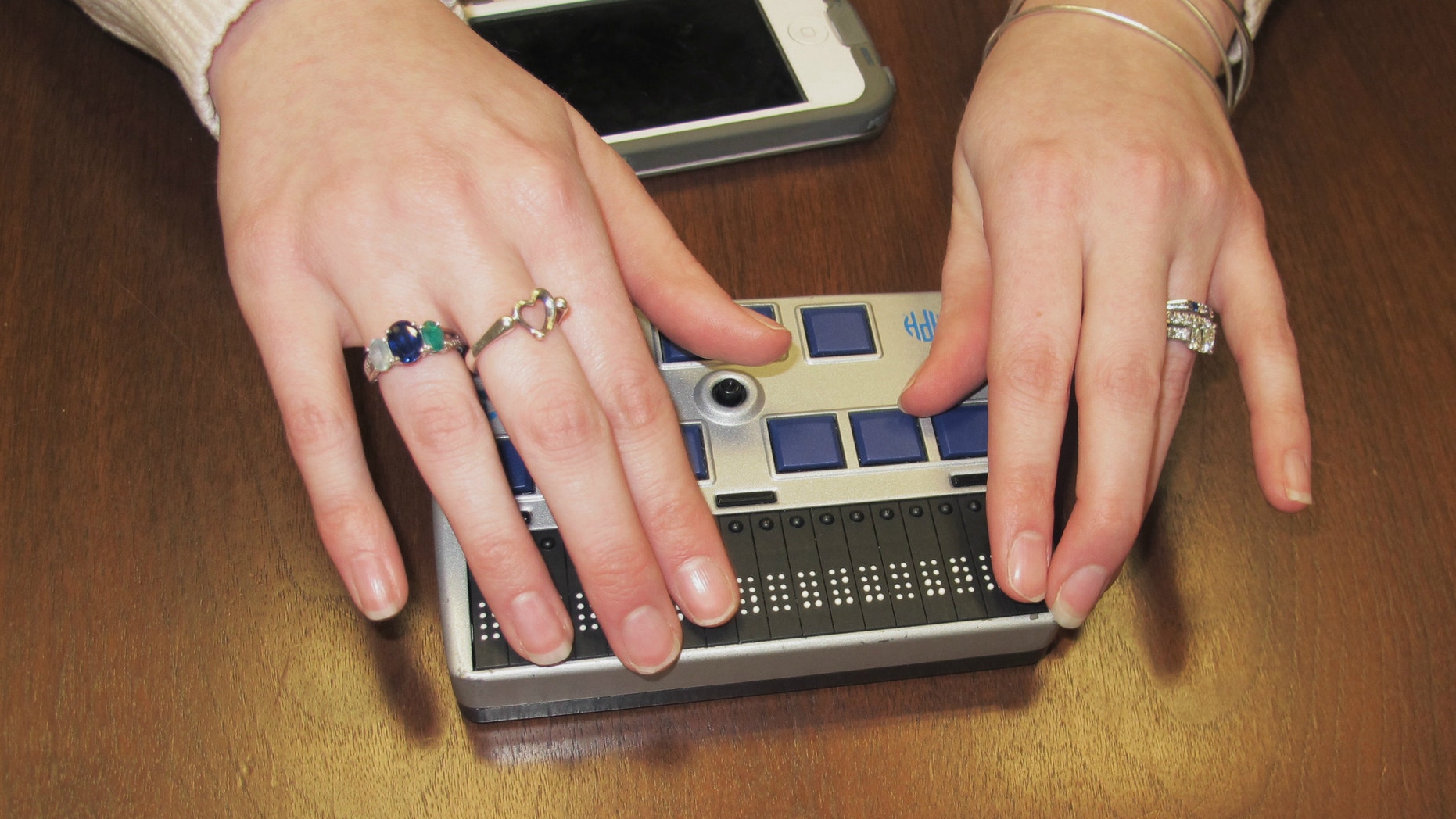 Megan Dausch, an instructor at the Helen Keller National Center, demonstrates the use of a Braille reader that helps blind clients access the Internet.