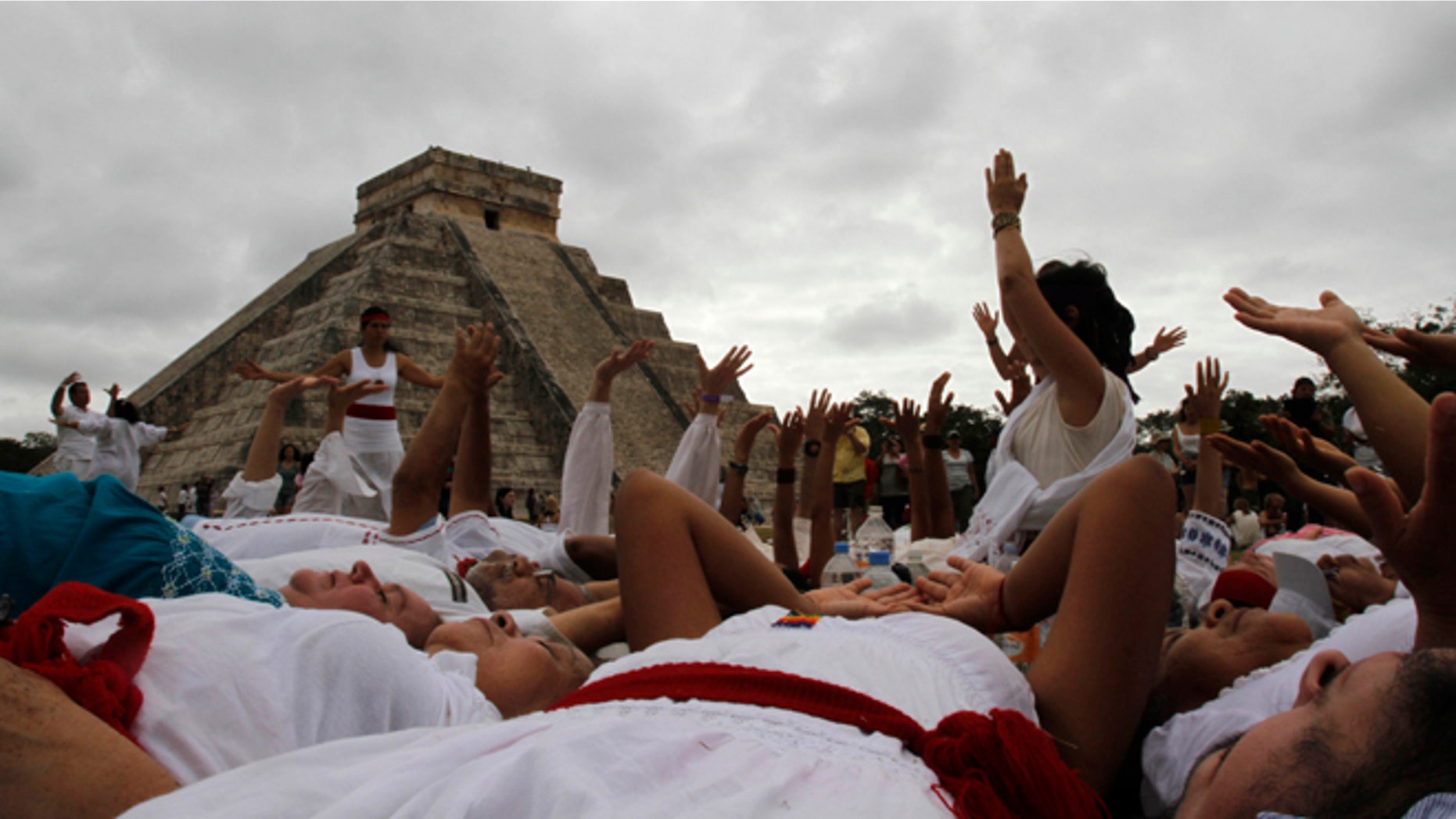 People participate in a ritual in fron of Kukulkan temple in Chichen Itza, Mexico, Friday, Dec. 21, 2012. At the ruins of the ancient Mayan city of Chichen Itza, thousands chanted, danced and otherwise frolicked around ceremonial fires and pyramids to mark the conclusion of a vast, 5,125-year cycle in the Mayan calendar. (AP Photo/Israel Leal)