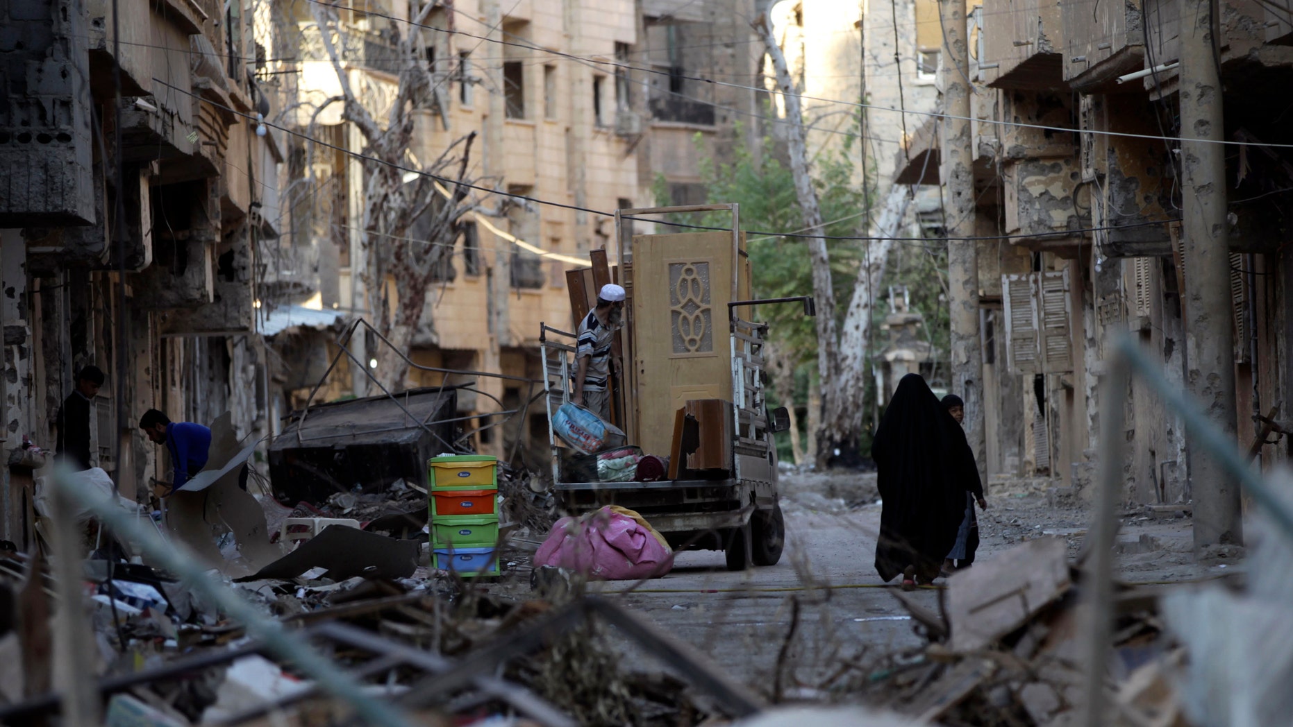 A family moves remnants of their house after it was damaged due to shelling in Deir al zor, Syria October 5, 2013. Now, at least 20 people are suspected of having contracted polio in this war-torn region of the country. (REUTERS/Khalil Ashawi)