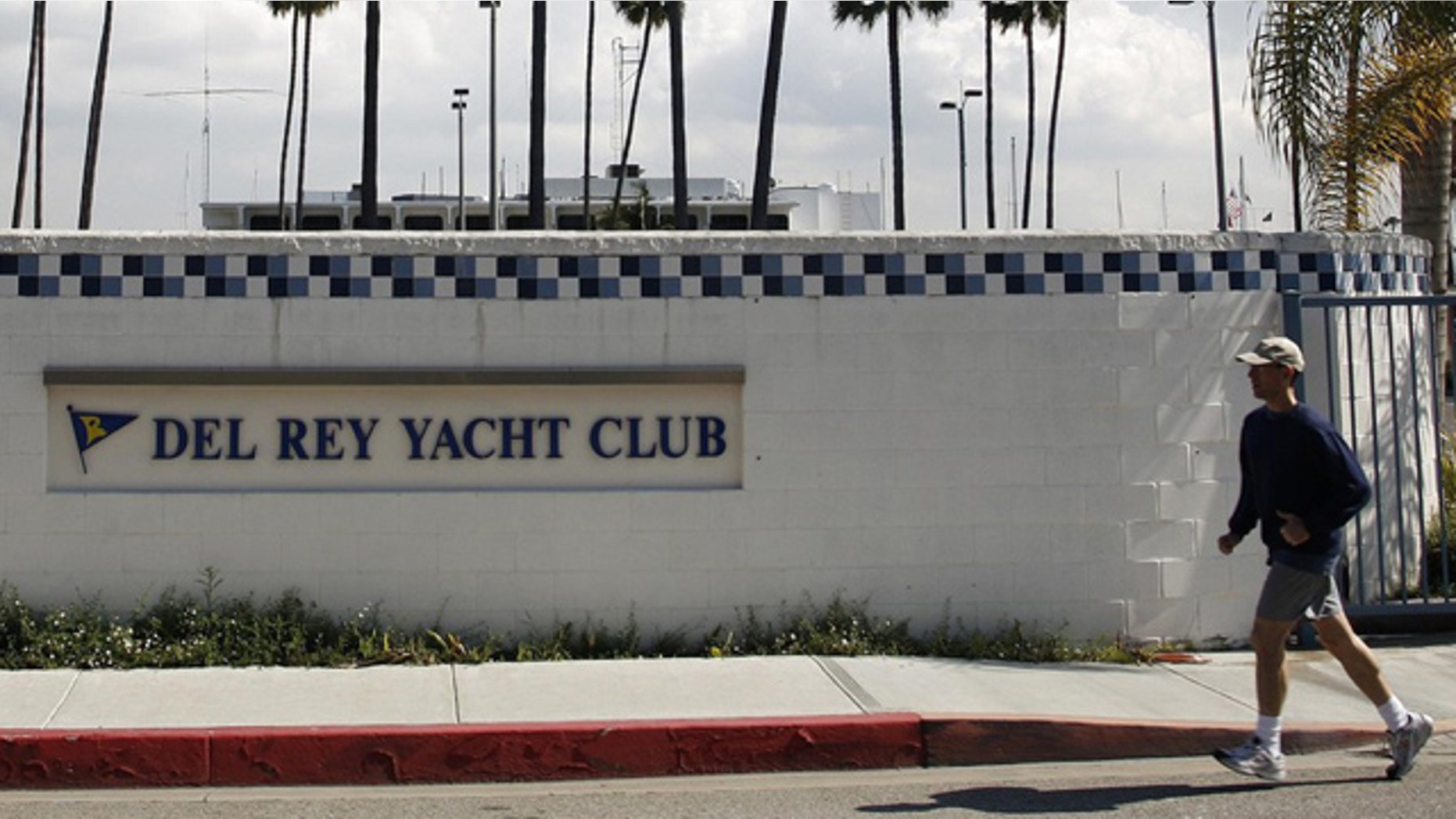 FILE 2011: A man jogs past the Del Rey Yacht Club where Jean and Scott Adams, two of the four Americans killed by Somali pirates, were members in Marina Del Rey, Calif.