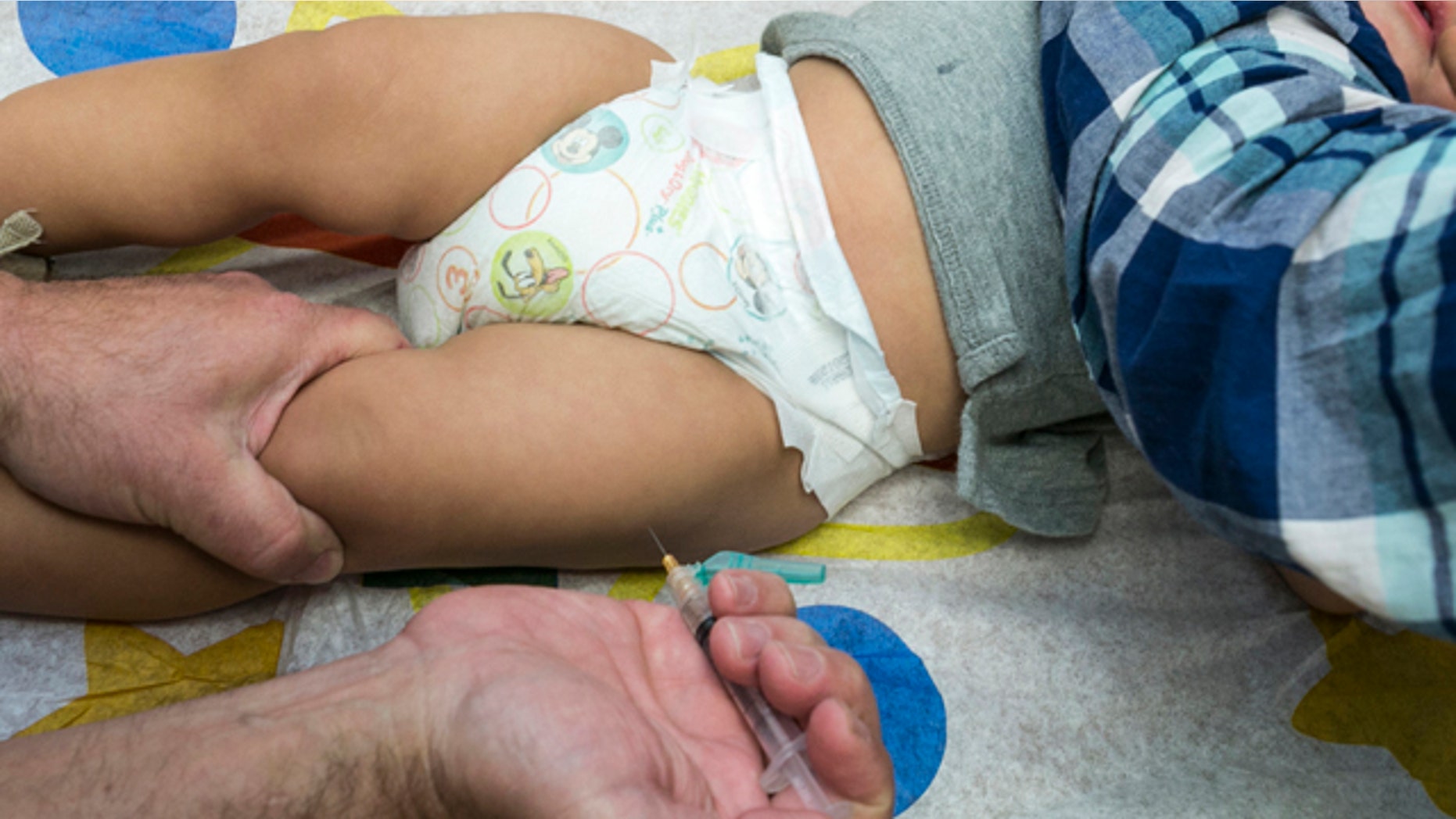 FILE - In this Jan. 29, 2015 file photo, a pediatrician uses a syringe to vaccinate a 1-year-old with the measles-mumps-rubella (MMR) vaccine in Northridge, Calif. (AP Photo/Damian Dovarganes, File)