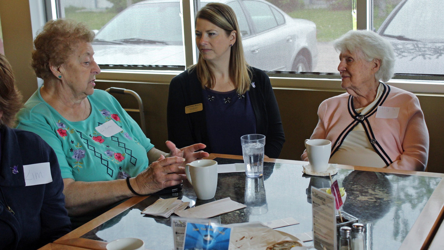 May 20, 2015: In this photo taken at Connections Cafe in Watertown, Wis., Shirley Strysick, right, 90, who suffers from dementia, talks with Stephanie Masche, center, from Heritage Homes assisted living facility, and an unidentified woman during a social and support group for those with the disease and their caregivers.