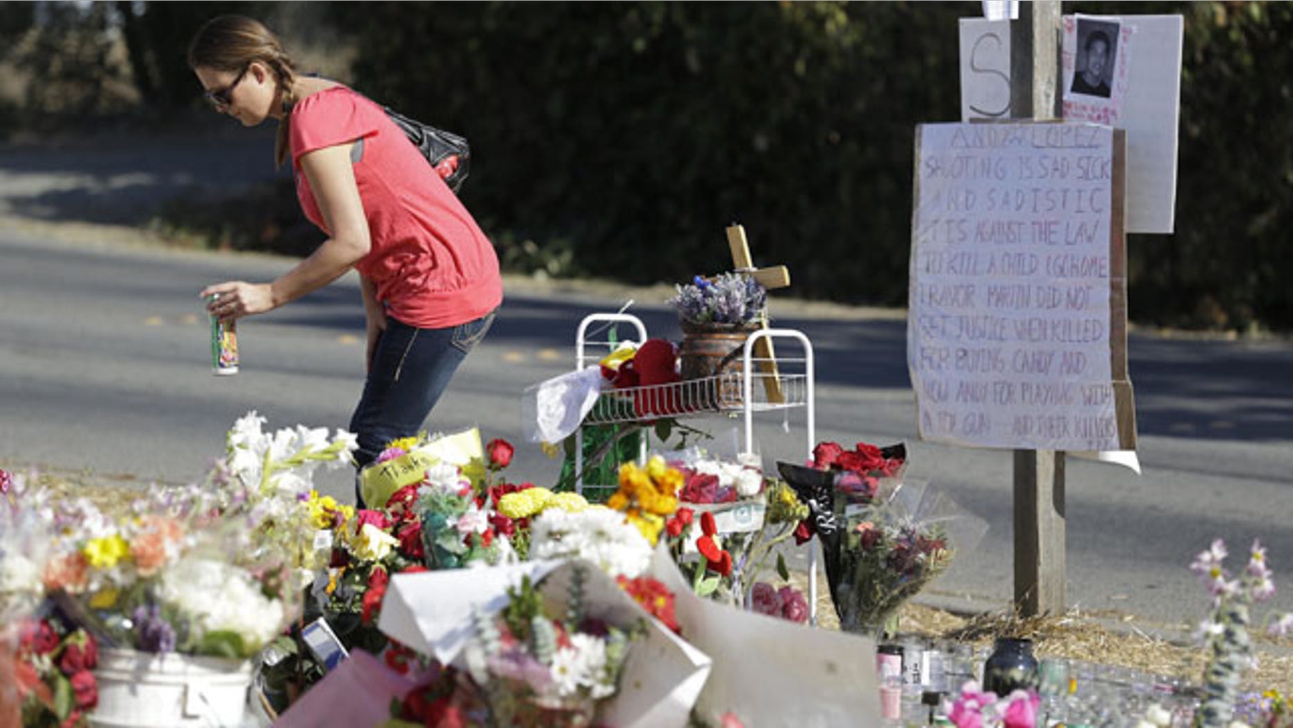 October 30, 2013: Robin Betts stops to place a candle at a memorial Wednesday in Santa Rosa, Calif., where Andy Lopez was killed last week by a sheriff's deputy. The 13-year-old boy was carrying a pellet gun that resembled an assault rifle (AP Photo)