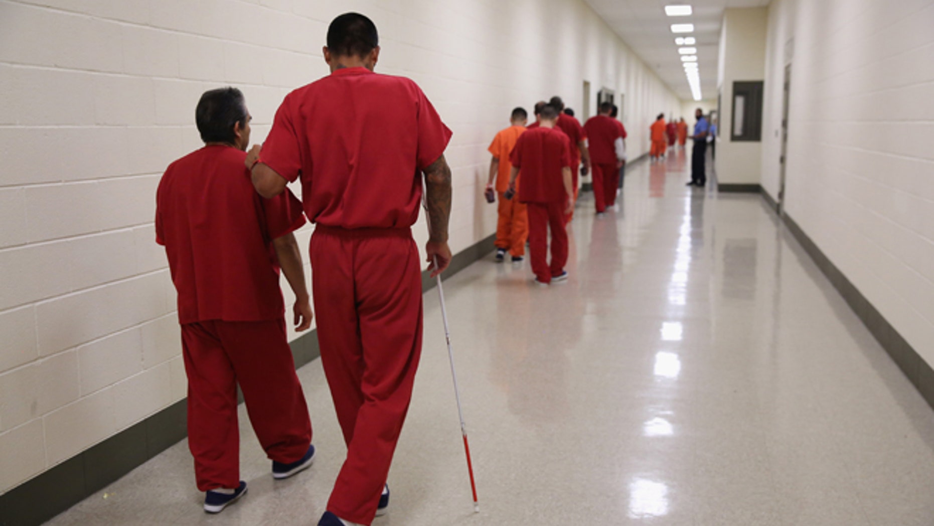 A blind detainee walks with a fellow immigrant at the Adelanto Detention Facility on November 15, 2013 in Adelanto, California. (Photo by John Moore/Getty Images)