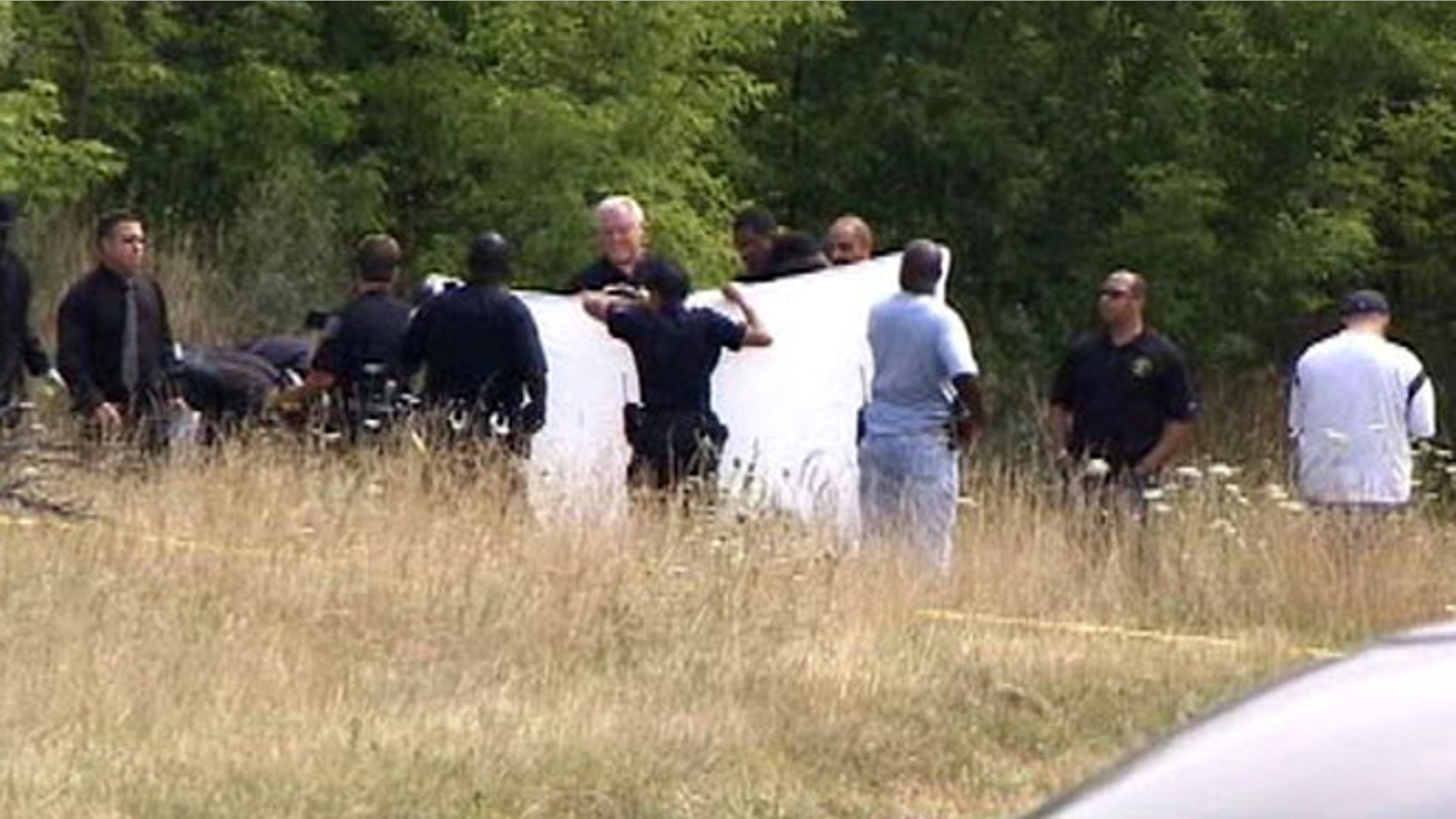 Detroit police block a road near where sources say two bodies were discovered Friday morning.