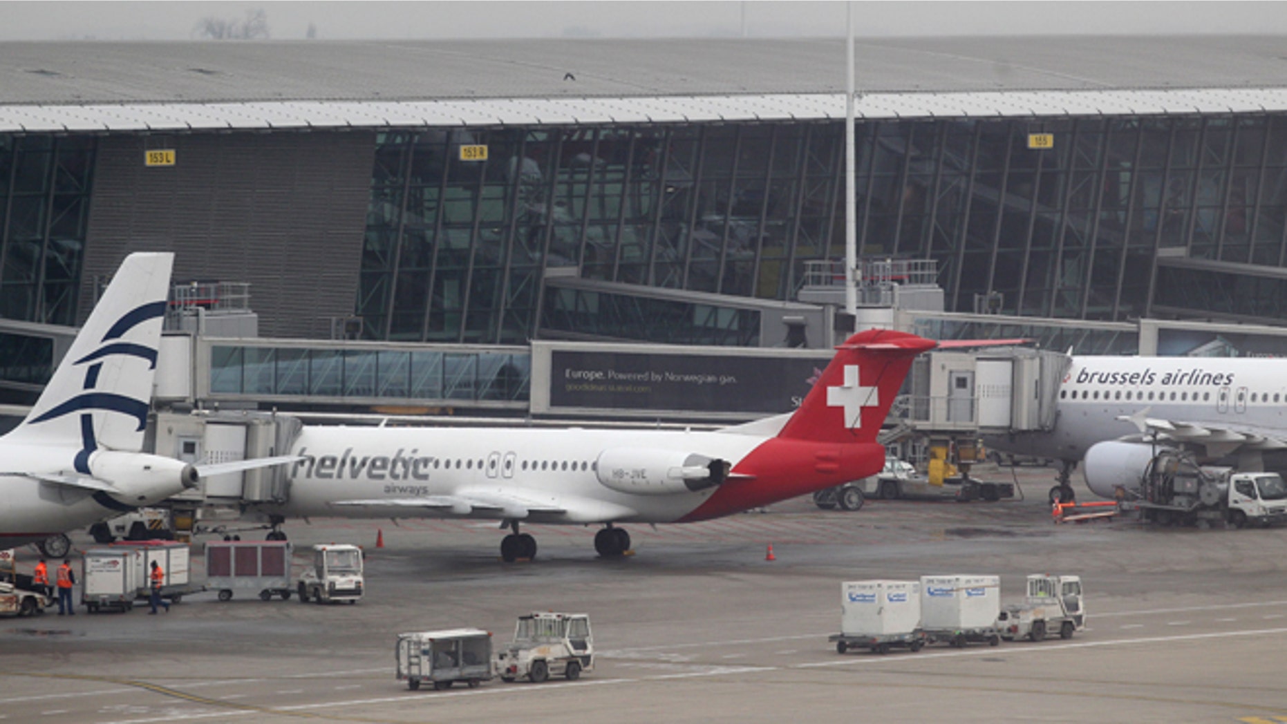 Feb. 19: Baggage carts make their way past a Helvetic Airways aircraft from which millions' of dollars worth of diamonds were stolen on the tarmac of Brussels international airport.