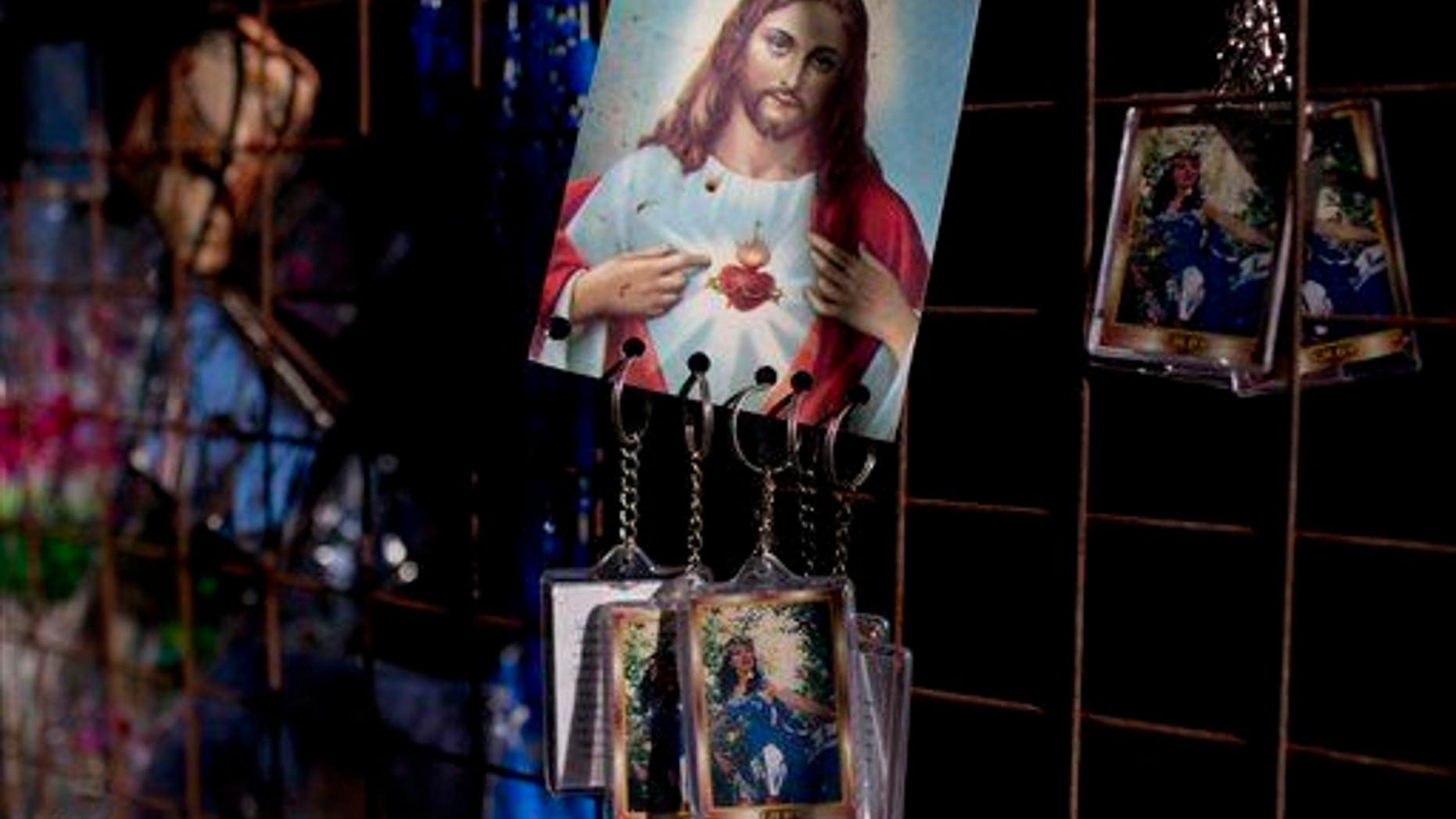 In this Sept. 7, 2014 photo, keychains of Argentina's late singer Gilda hang from a picture of Jesus Christ inside a sanctuary at the site where she died in a bus crash on the anniversary of her death in Entre Rios, Argentina. After the Argentine singer died at age 35 in a tragic road accident, her fans began attributing miracles to her, and gathering here on her birthday and the anniversary of her death to pray and thank her. (AP Photo/Natacha Pisarenko)