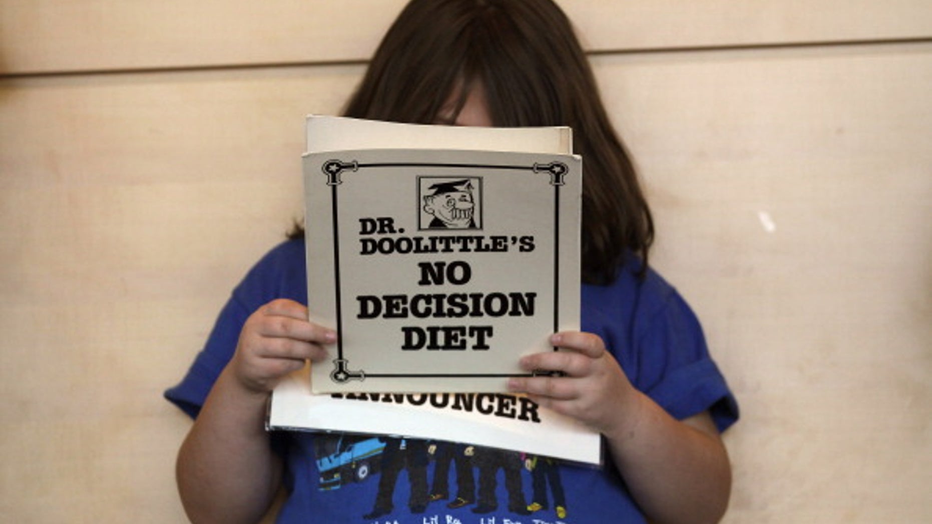 An overweight child reads her part in a humorous skit held during a program for overweight adolescents in Colorado.