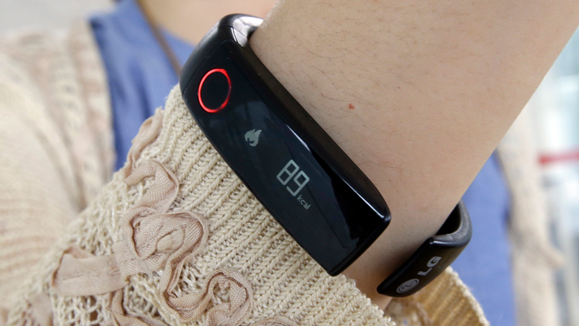 In this June 5, 2014 photo, a reporter shows LGs Lifeband Touch for photographs in Seoul, South Korea.