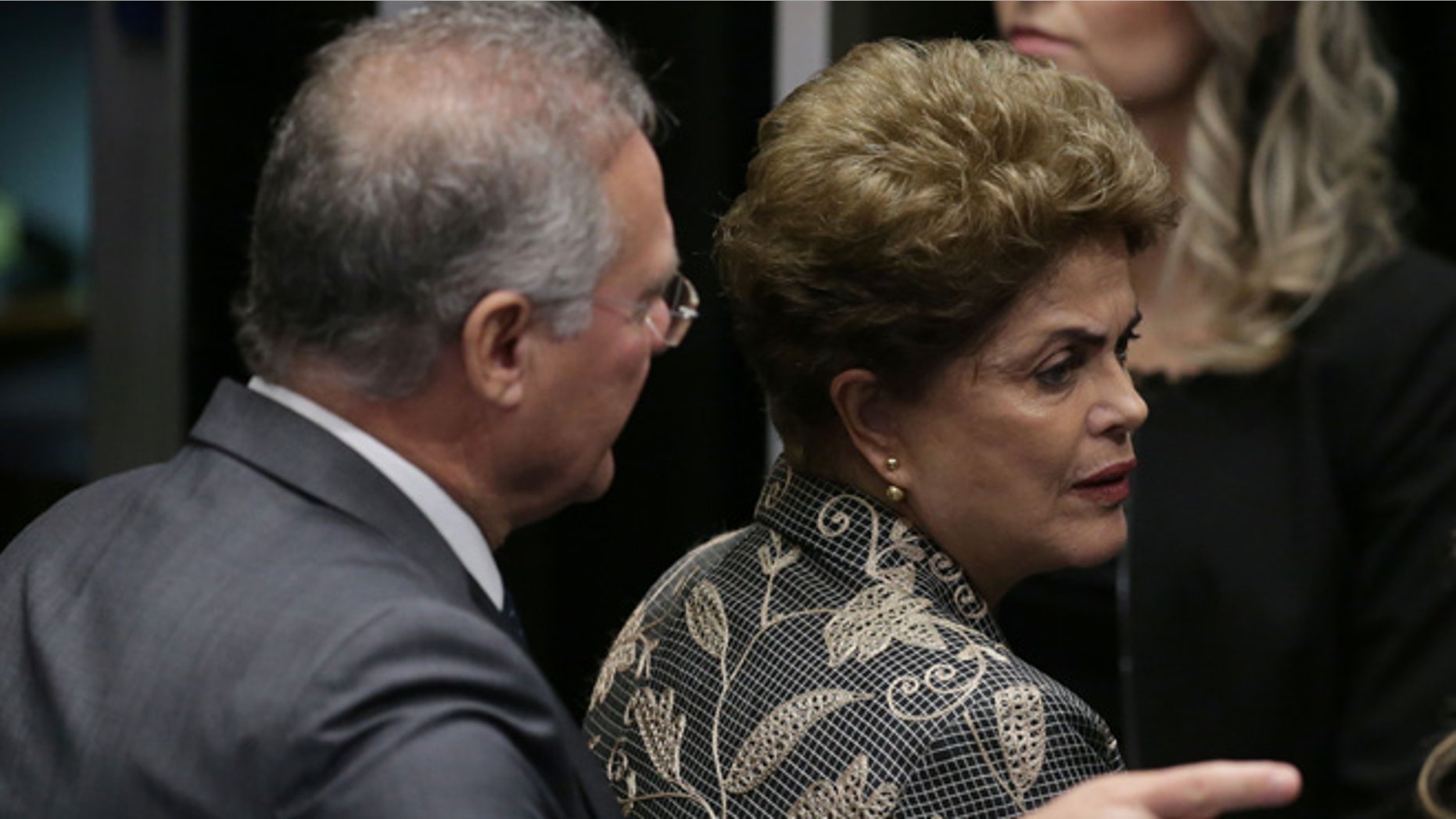 Brazil's Senate leader Renan Calheiros points to an exit as suspended President Dilma Rousseff looks to leave Senate chambers after addressing the lawmakers, at the start of a short recess of her own impeachment trial, in Brasilia, Brazil, Monday, Aug. 29, 2016. Fighting to save her job, Rousseff told senators on Monday that the allegations against her have no merit. "I know I will be judged, but my conscience is clear. I did not commit a crime," she told senators. Rousseff's address comes on the fourth day of the trial. (AP Photo/Eraldo Peres)