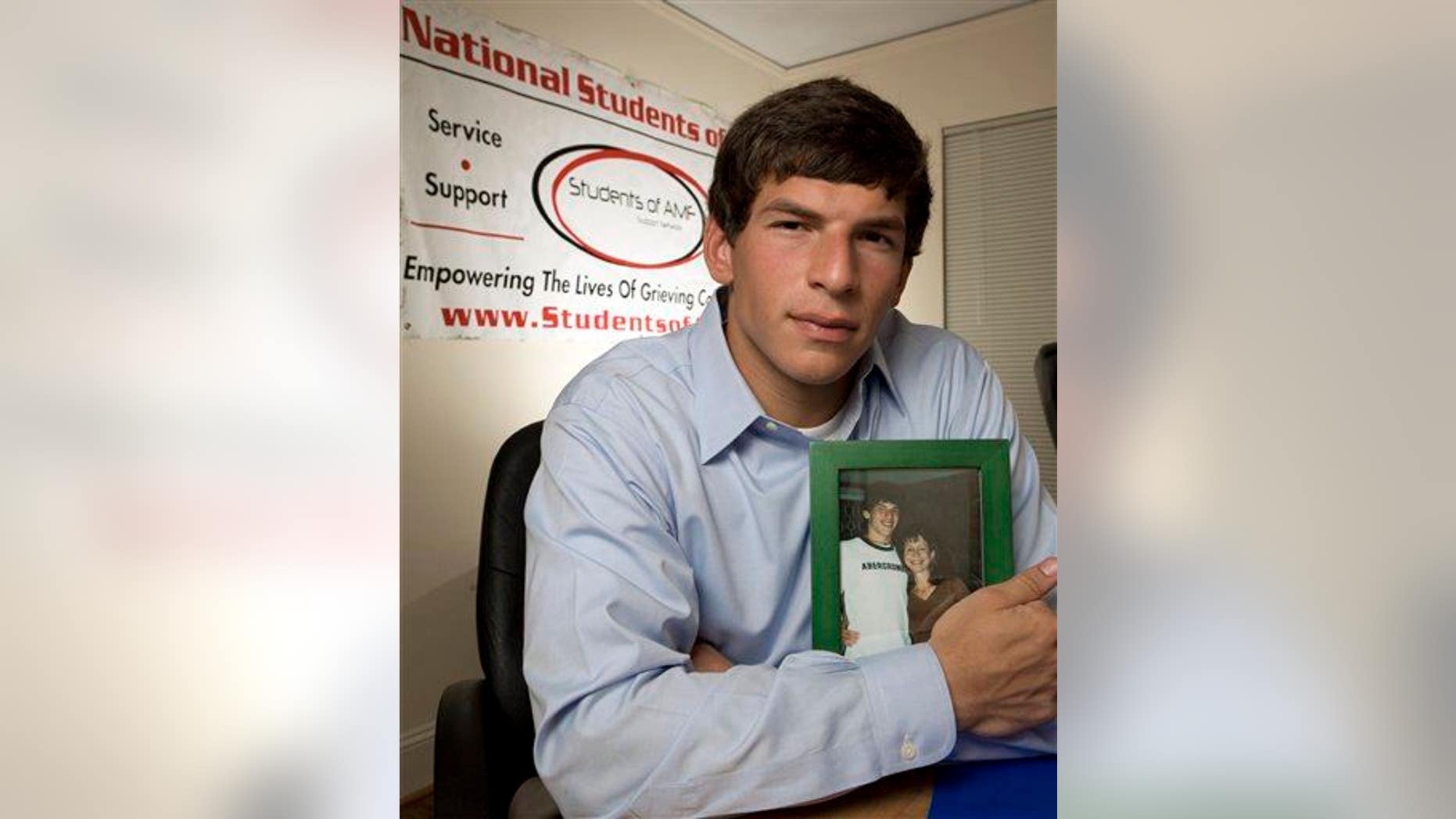 Before he became a doctor and researcher, David Fajgenbaum founded Students of Ailing Mothers and Fathers while at Georgetown after his mother died of brain cancer. He holds her photo at his home in Raleigh, NC, June 29, 2007.