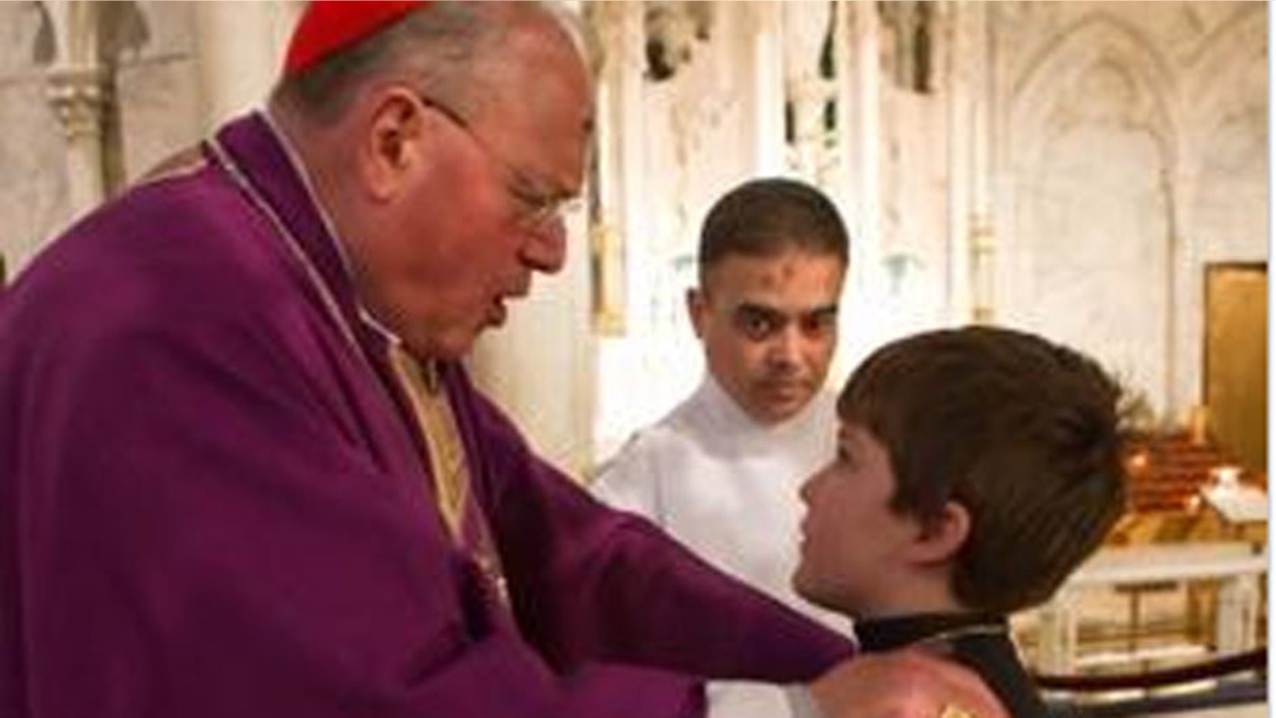 ASH WEDNESDAY: Cardinal Dolan extols altar boy Chris Sweeney after Ash Wednesday services at St. Patrick's in New York.