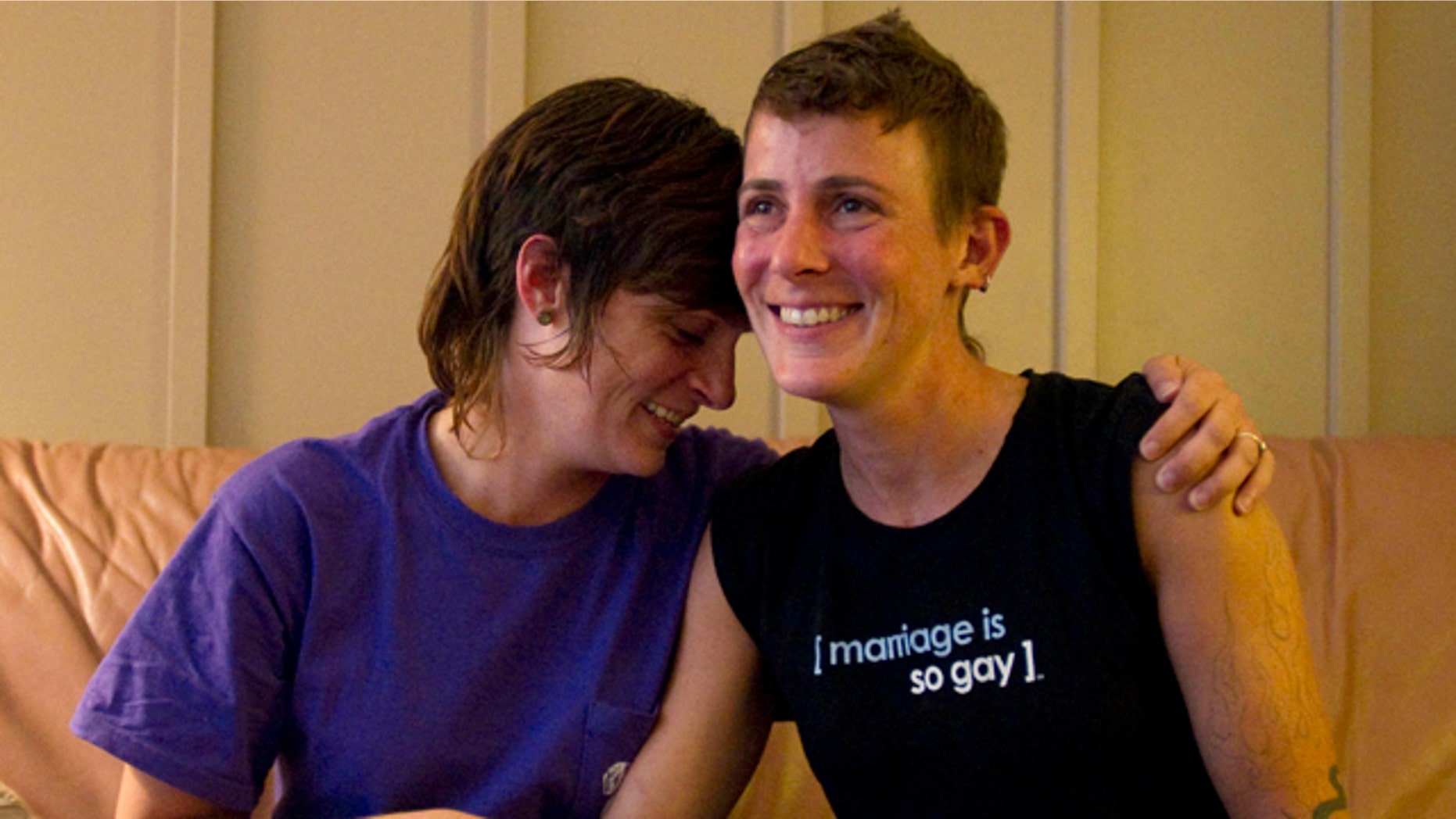 July 25: Lesbian couple Jennifer Tipton, left, and Olivier Odom are seen at a coffee house in Knoxville, Tenn. The couple are calling for Dollywood Splash County to be more inclusive to its guests after they were asked to reverse the pro-gay marriage T-shirt worn by Odom, during a recent visit.