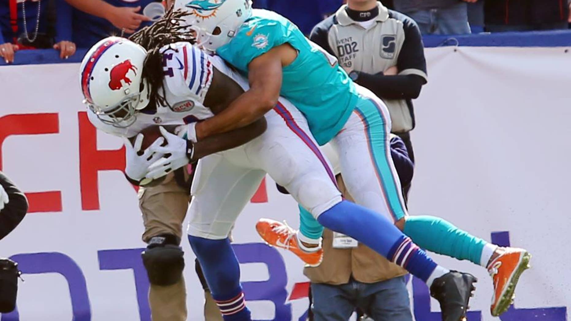 Buffalo Bills wide receiver Sammy Watkins (14) scores a touchdown as he is tackled by Miami Dolphins cornerback Brent Grimes during the second half of an NFL football game on Sunday, Sept. 14, 2014, in Orchard Park, N.Y. (AP Photo/Bill Wippert)