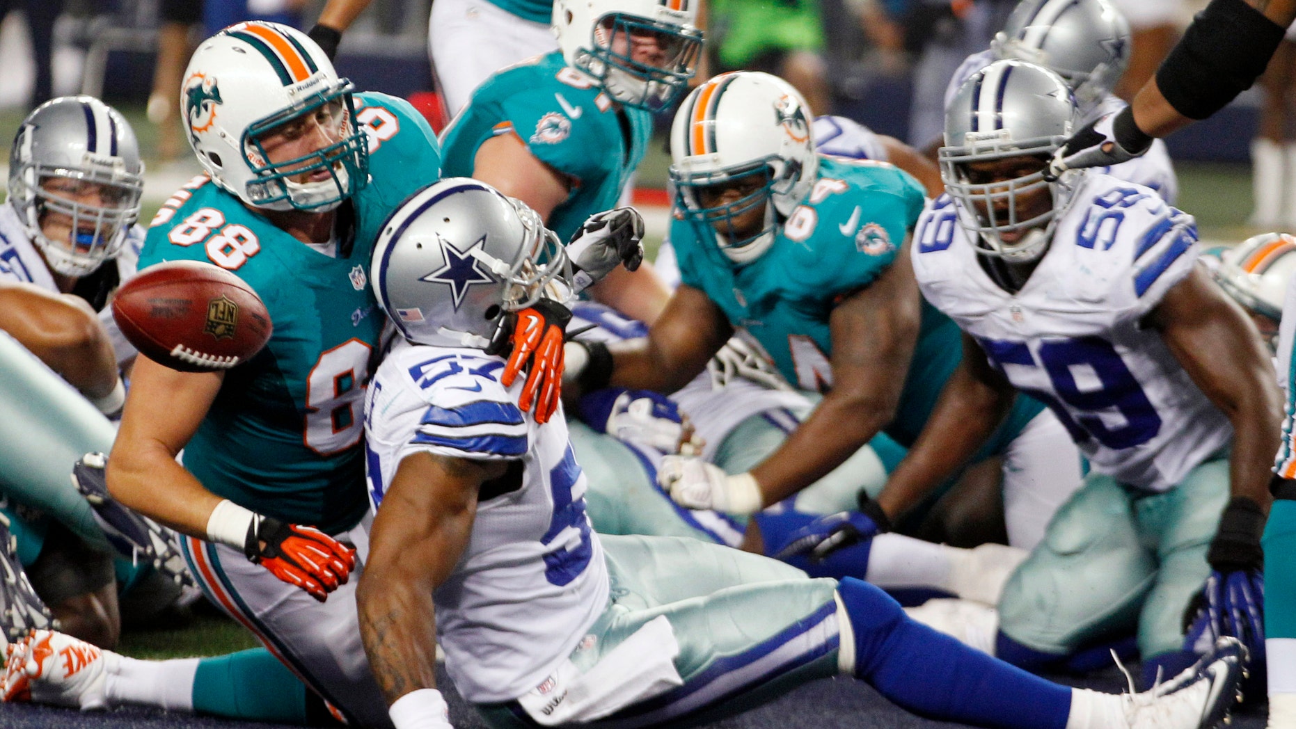 Aug. 29, 2012: Miami Dolphins tight end Jeron Mastrud (88) tangles with Dallas Cowboys linebacker Victor Butler (57) as the ball pops loose after a touchdown scored by Dolphins' Lamar Miller (not shown) during the third quarter of the NFL preseason football game, in Arlington, Texas.
