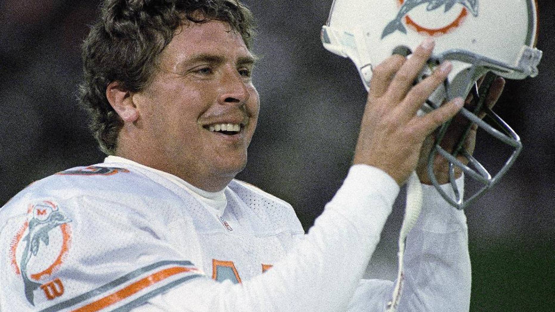 FILE - In this Nov. 27, 1994, file photo, Miami Dolphins quarterback Dan Marino removes his helmet after throwing the winning touchdown against the New York Jets during fourth-quarter action of an NFL football game in East Rutherford, N.J. It is almost 20 years to the day since the Jets led 24-21 with 30 seconds left and the Dolphins had the ball at the New York 8. (AP Photo/Eric Miller, File)
