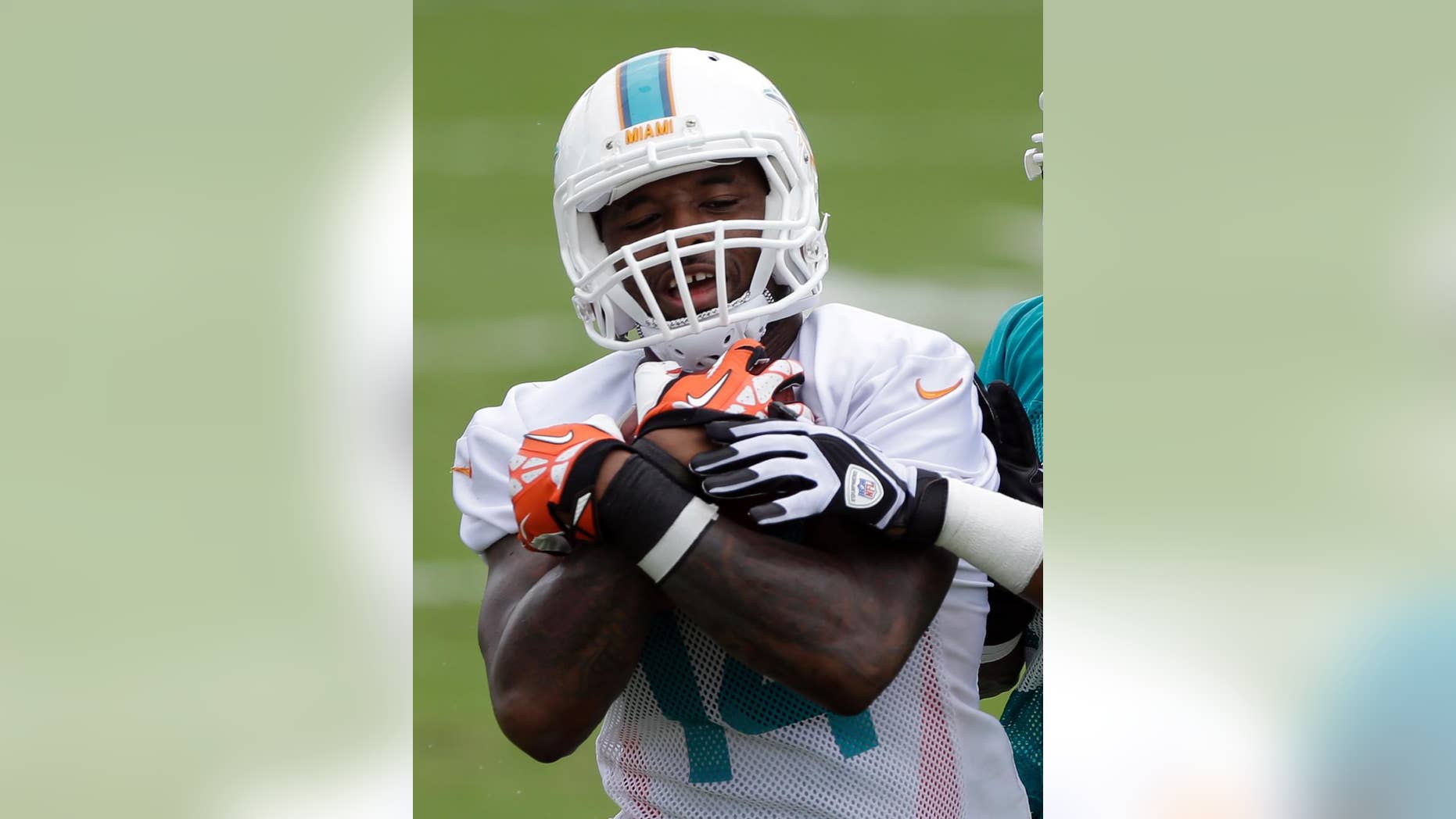 Miami Dolphins wide receiver Jarvis Landry holds on to the ball during NFL football training camp Saturday, July 26, 2014, in Davie, Fla. Training camp has barely begun, and Miami Dolphins rookie receiver Jarvis Landry has already showed an ability to catch the ball and the boss' eye. When team owner Stephen Ross was asked what player he's most excited to see this season, he named Landry, the second-round draft choice from Louisiana State. During offseason drills and the first two days of camp, Landry has impressed the Dolphins with his sure hands and ability to get open. (AP Photo/Alan Diaz)