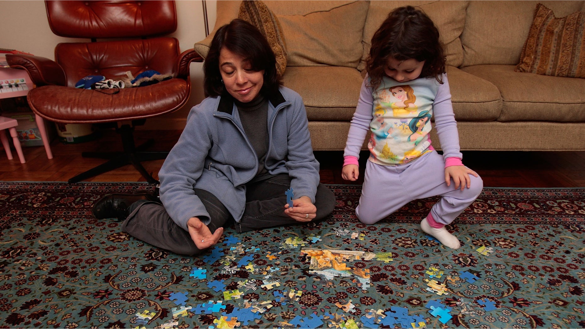 NEW YORK - DECEMBER 11: Jocelyn Taub, a job-hunting marketing professional, works on a puzzle with a three-year-old girl while babysitting for extra money December 11, 2008 in New York City. Taub has worked in the music promotion and radio business her whole career, but was let go from her job 10 months ago and has been job searching ever since. To make ends meet, she's been working odd jobs in offices for friends and is doing some babysitting. "I've seen downturns before, but it's never been like this," she says. (Photo by Chris Hondros/Getty Images)
