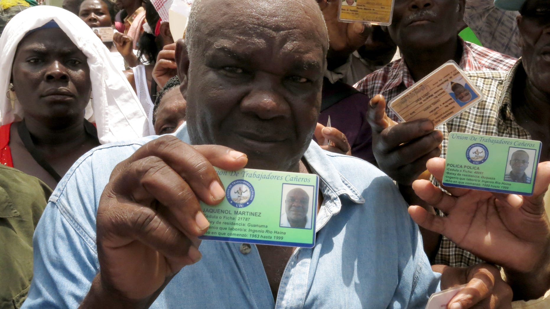 Haitian Jaquenol Martinez shows a card that proves that he has worked in the Dominican sugar cane fields since 1963, while trying to apply for a temporary resident permit, in Santo Domingo, Dominican Republic, Monday, June 15, 2015. Hundreds of Haitians are waiting in long lines throughout the Dominican Republic trying to secure legal residency as they face the threat of deportation. The government has given non-citizens until Tuesday to register under an initiative aimed at regulating the flow of migrants from neighboring Haiti. (AP Photo/Ezequiel Abiu Lopez)