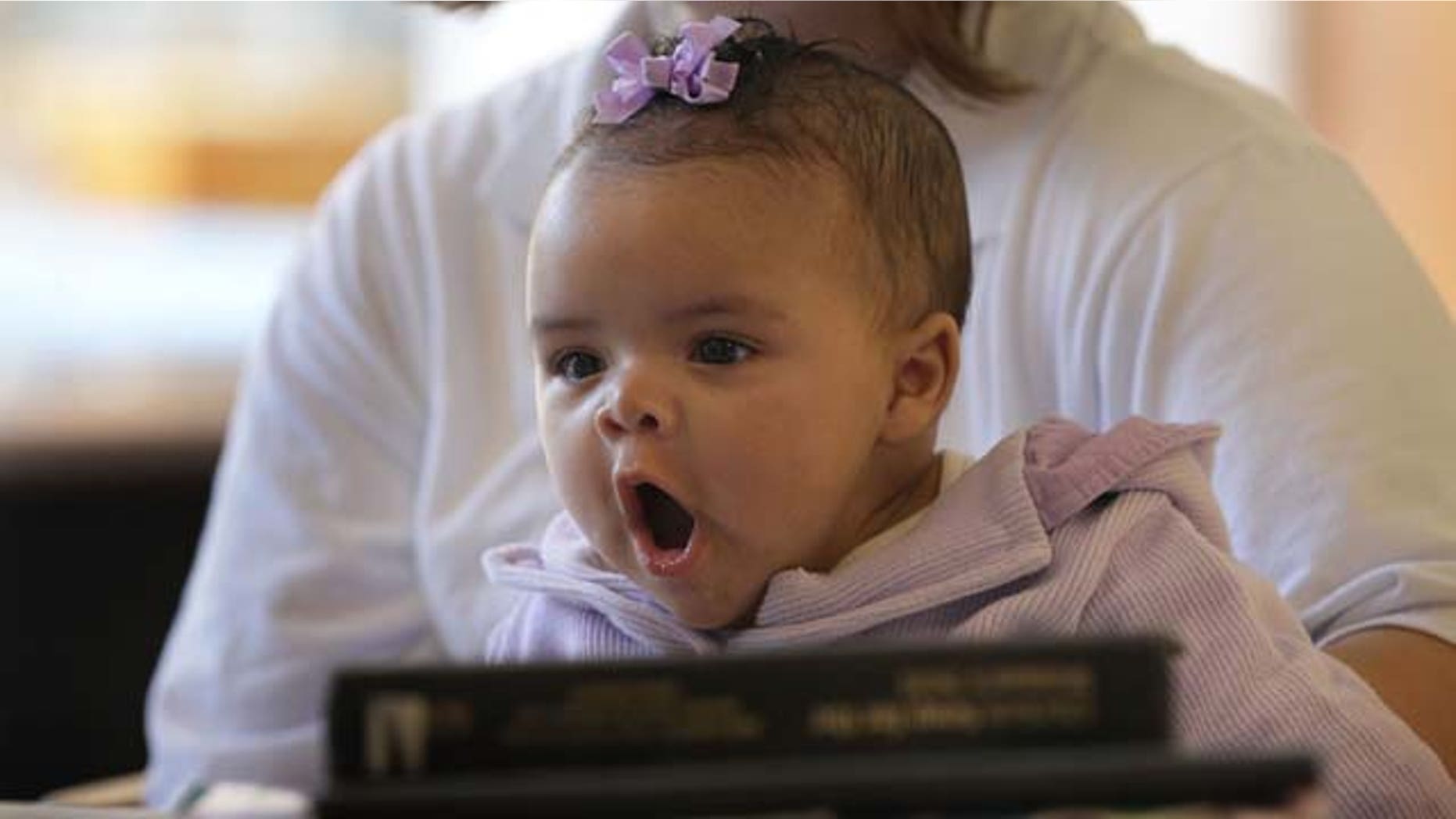 DECATUR, IL - FEBRUARY 18: Three-month-old Alexis sits on her mother's lap in the common area of her ward at the Decatur Correctional Center February 18, 2011 in Decatur, Illinois. Alexis, who was born while her mother Brandi Ceci was serving a 54 month sentence for burglary, lives with her mother at the prison, part of the Moms with Babies program at the minimum security facility. The program allows incarcerated women to keep their newborn babies with them for up to two years while serving their sentence. The program boasts a zero percent recidivism rate compared to the statewide rate of 51.3 percent. (Photo by Scott Olson/Getty Images)
