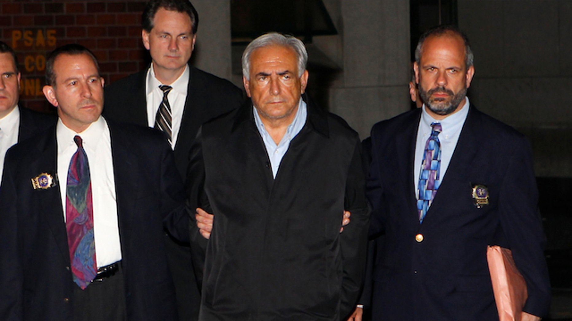 Dominique Strauss-Kahn (C), head of the International Monetary Fund (IMF), departs a New York Police Department precinct in New York late May 15, 2011. A handcuffed IMF chief, Dominique Strauss-Kahn, facing charges he sexually assaulted a hotel maid, was escorted from a New York Police Department unit late on Sunday. REUTERS/Mike Segar (UNITED STATES - Tags: CRIME LAW BUSINESS IMAGES OF THE DAY)