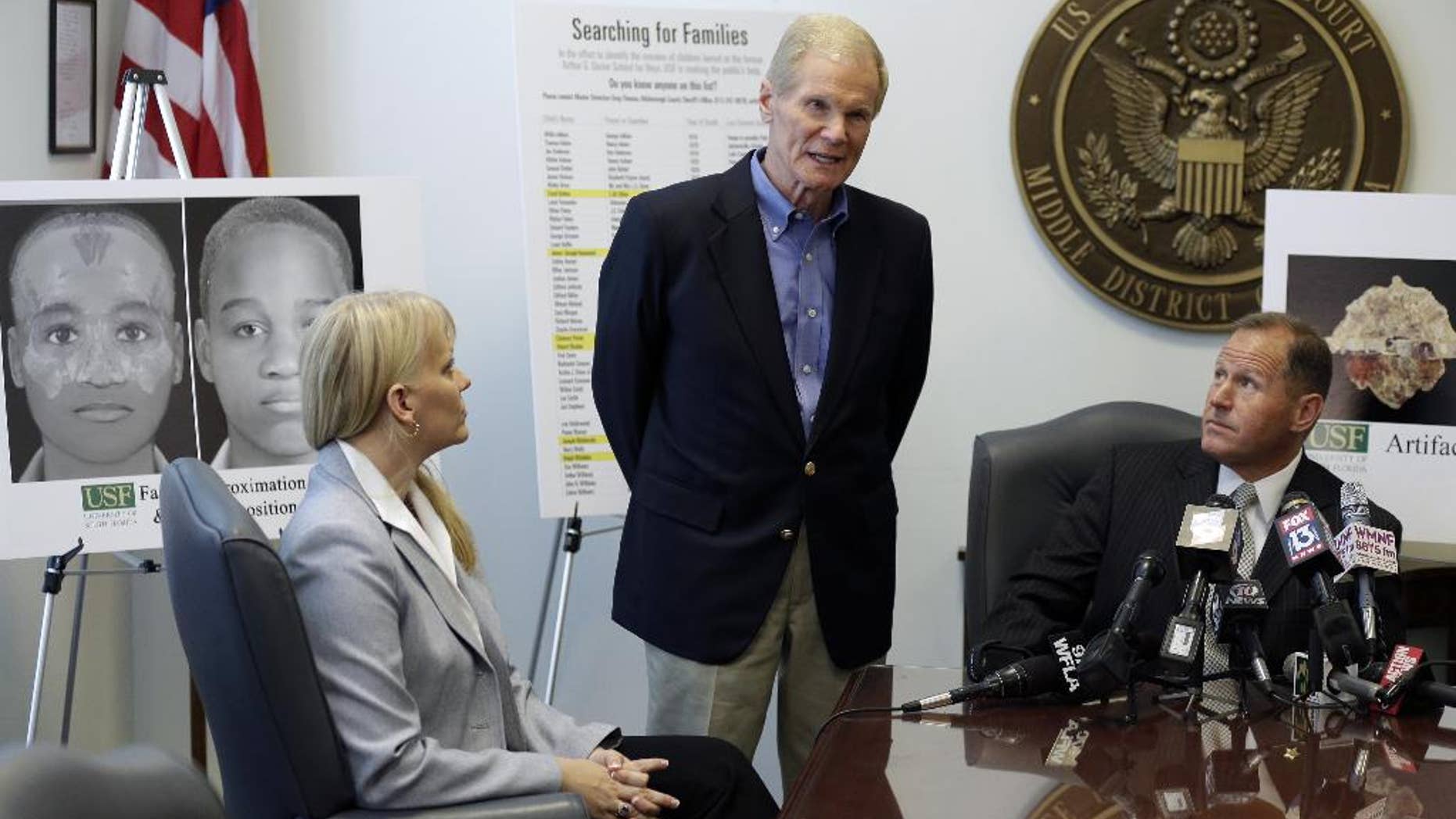 FILE - In this April 15, 2014, file photo, U.S. Sen. Bill Nelson, center, D-Fla., along with University of South Florida Associate Professor Erin Kimmerle, left, and Hillsborough County Sheriff David Gee, right, speak to the media about the on-going research being done at the Arthur G. Dozier School for Boys in Marianna, Fla., at the United States Courthouse, in Tampa, Fla. Researchers studying dozens of graves and deaths at a now closed Florida reform school describe a long history of horrific treatment of the boys. A report released by University of South Florida researchers this week identifies two more of the people buried in the graves. (AP Photo/Chris O'Meara, File)