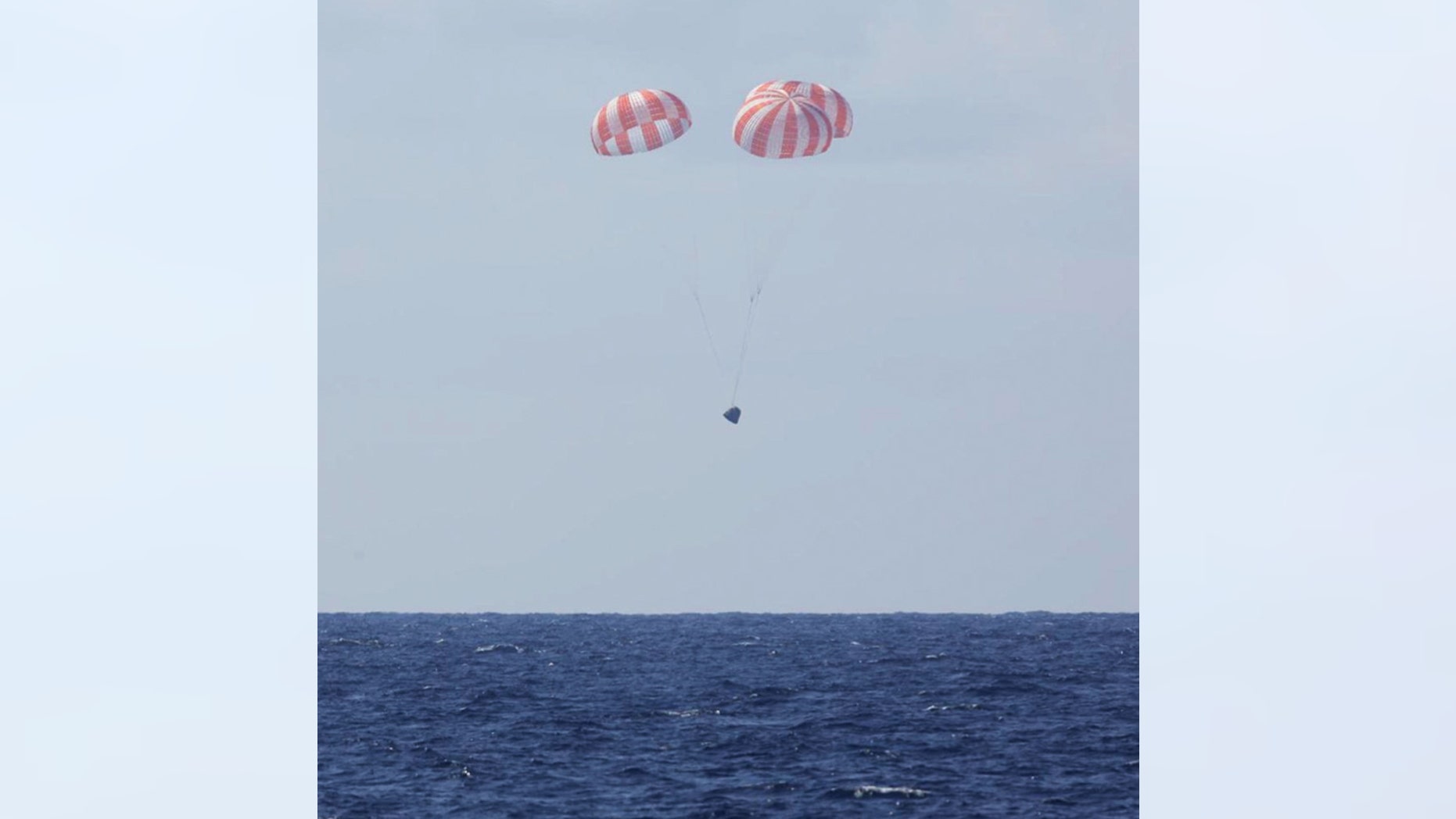 In this photo made available by SpaceX, the Dragon capsule uses parachutes to land in the Pacific Ocean near Southern California, returning from the International Space Station in orbit on Thursday, May 21, 2015.