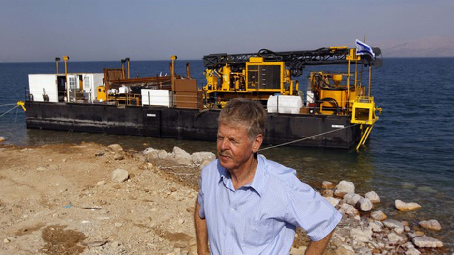 Zvi Ben-Avraham, head of the drilling project, stands in front of a moored drilling platform on the shore of the Dead Sea, near Kibbutz Ein Gedi November 16, 2010. A group of engineers and scientists will analyze 500,000 years of geological history, deciphering patterns and using them to find the best way to manage the earth's resources and environment.
