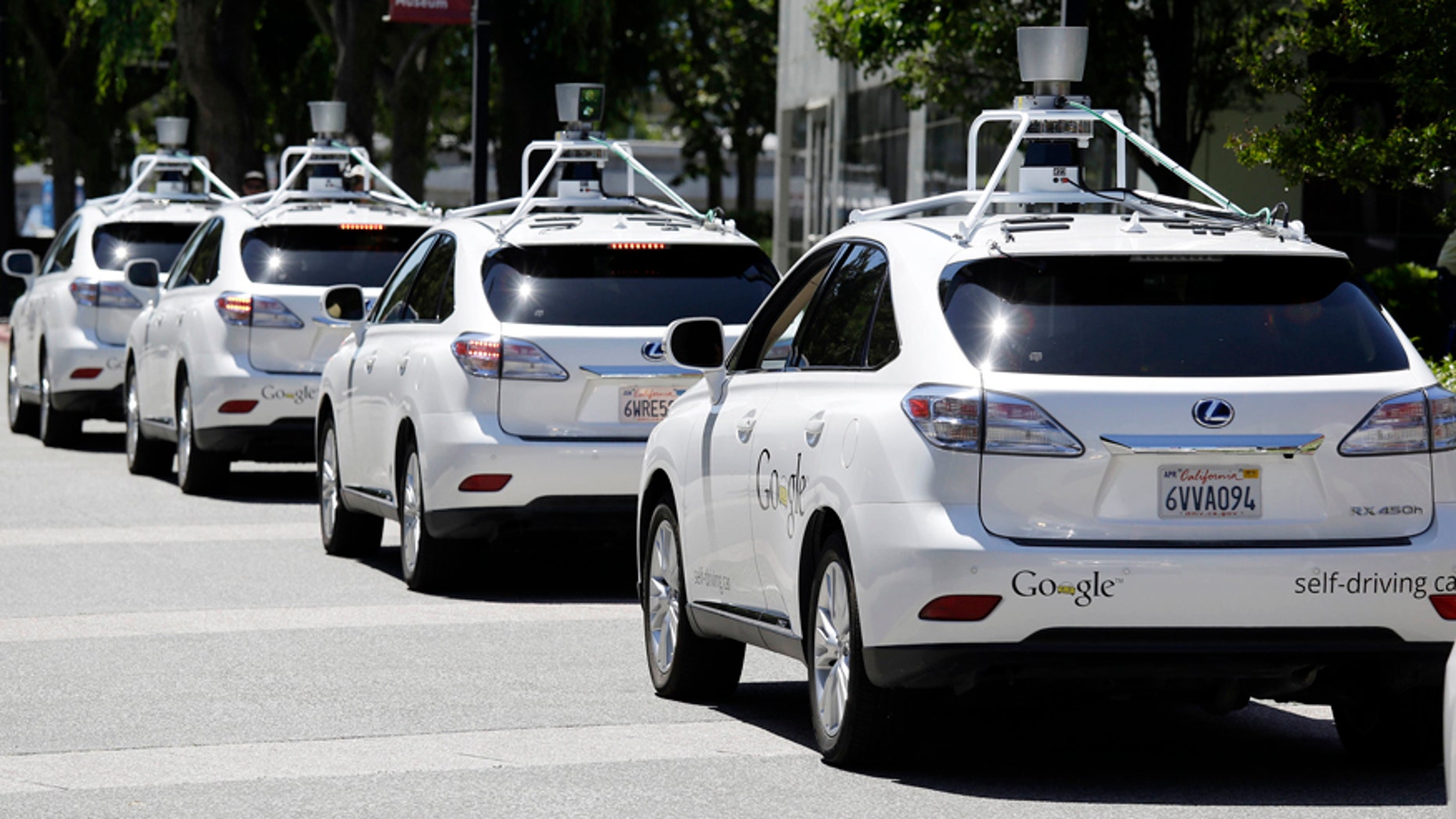 FILE - This May 13, 2014 file photo shows a row of Google self-driving cars in Mountain View, Calif. (AP Photo/Eric Risberg, File)
