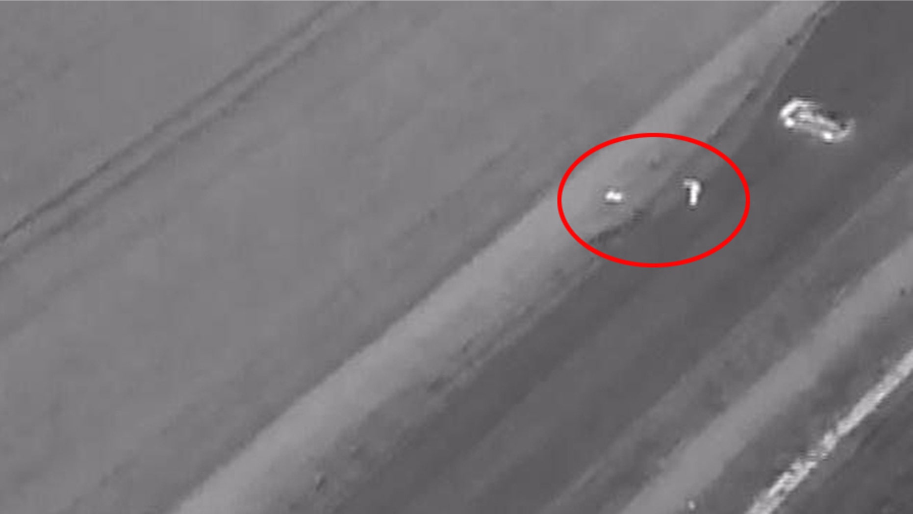 Drone footage shows a police officer (circled, right), finding the unconscious man (Lincolnshire Police)