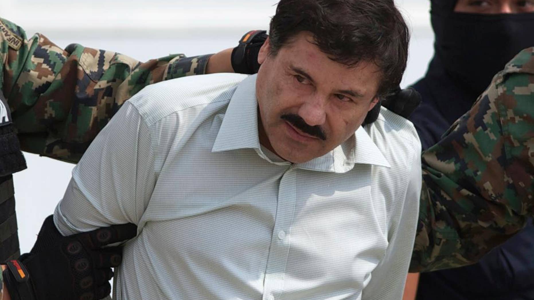FILE - This Feb. 22, 2014 file photo shows Joaquin "El Chapo" Guzman, the head of Mexico’s Sinaloa Cartel, being escorted to a helicopter in Mexico City following his capture overnight in the beach resort town of Mazatlan. On Monday, Nov. 24, 2014, at federal court in Chicago, a U.S. judge sentenced Alfredo Vasquez-Hernandez, a reputed lieutenant of Guzman, to 22 years in prison for his role in a $1 billion trafficking conspiracy, saying the stiff sentence should send a message to traffickers everywhere. The case is regarded as one of the U.S. government's most important against Mexican cartels. Guzman remains jailed in Mexico and Mexican authorities haven't said if they might extradite him to Chicago. (AP Photo/Eduardo Verdugo, File)