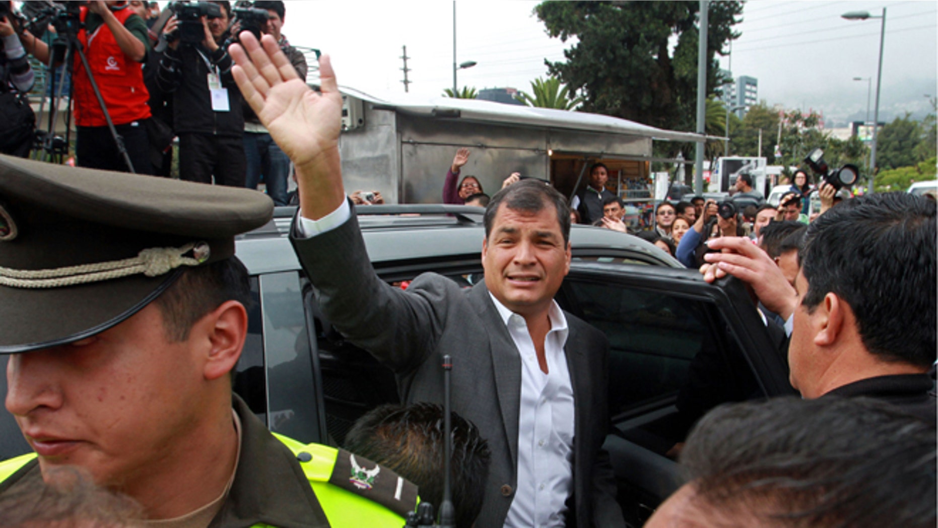 President Rafael Correa waves to supporters as he leaves a polling station after voting in Quito, Ecuador, Sunday, Feb. 17, 2013. President Rafael Correa gestures to photographers as he votes at a polling station in Quito, Ecuador, Sunday, Feb. 17, 2013. Ecuadoreans elect president, vice-president and National Assembly members Sunday with Correa highly favored to win a second re-election.(AP Photo/Martin Jaramillo)