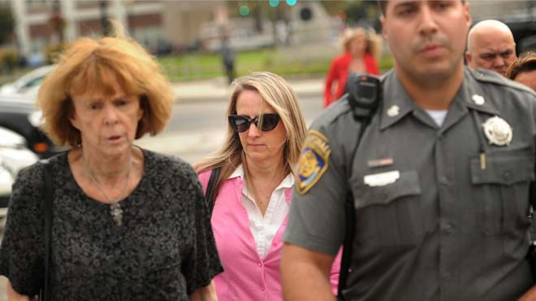 Oct. 13: Jennifer Connell, center, is escorted to her car by marshals after her lawsuit against her Westport nephew was found in his favor in Superior Court in Bridgeport, Conn.