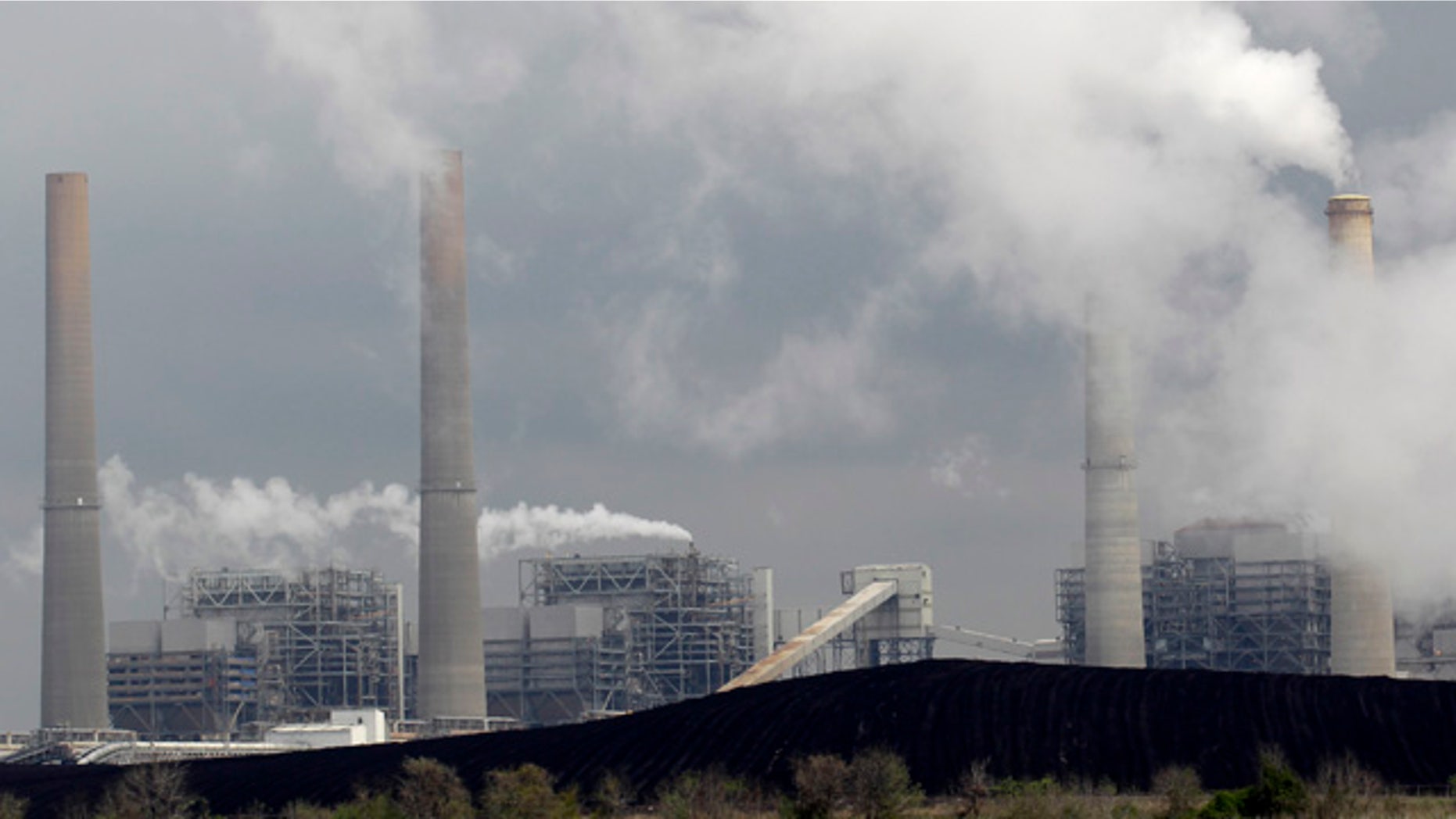 FILE - In this March 16, 2011, file photo, exhaust rises from smokestacks in front of piles of coal in Thompsons, Texas. (AP Photo/David J. Phillip, File)