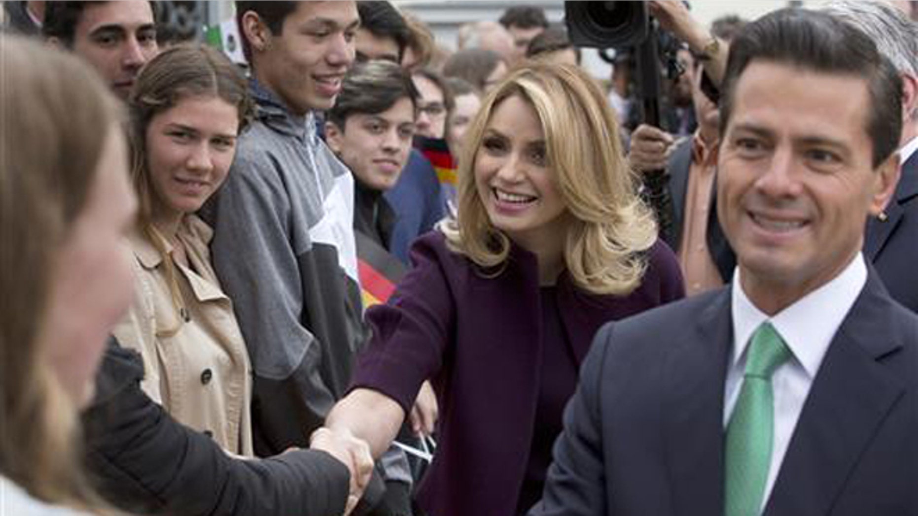 In this April 11, 2016 file photo, Mexico's President Enrique Pena Nieto, right, and his wife Angelica Rivera de Pena greet students as they arrive to meet with Germany's President Joachim Gauck at Bellevue Palace in Berlin, Germany. Pena Nieto apologized on Monday, July 18, 2016 for a 2014 scandal involving a mansion his wife bought from a firm that won lucrative contracts with his administration. (AP Photo/Michael Sohn, File)