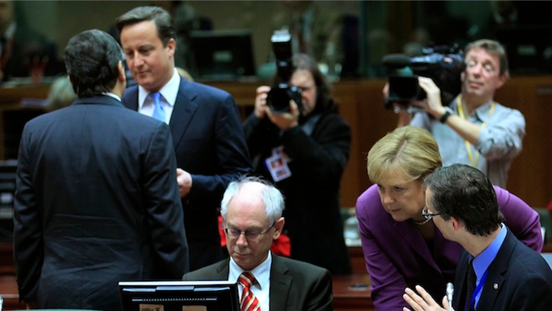 FILE: European Commission President Jose Manuel Barroso talks with Britain's Prime Minister David Cameron while Germany's Chancellor Angela Merkel (2ndR) speaks with European Council President Herman Van Rompuy (C) at a European Union summit in Brussels.