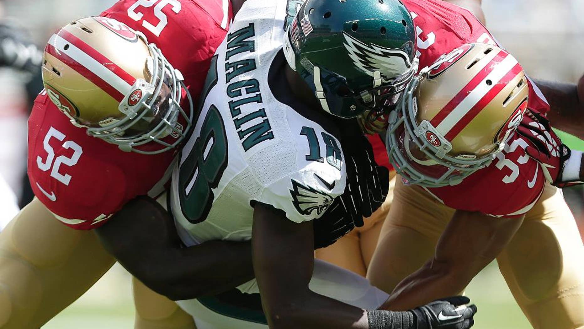 Philadelphia Eagles wide receiver Jeremy Maclin (18) is tackled by San Francisco 49ers linebacker Patrick Willis (52) and safety Eric Reid (35) during the first quarter of an NFL football game in Santa Clara, Calif., Sunday, Sept. 28, 2014. (AP Photo/Marcio Jose Sanchez)