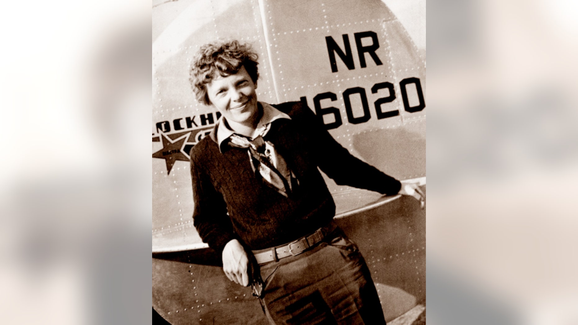 This May 20, 1937 photo, provided by The Paragon Agency, shows aviator Amelia Earhart at the tail of her Electra plane, taken by Albert Bresnik at Burbank Airport in Burbank, Calif.