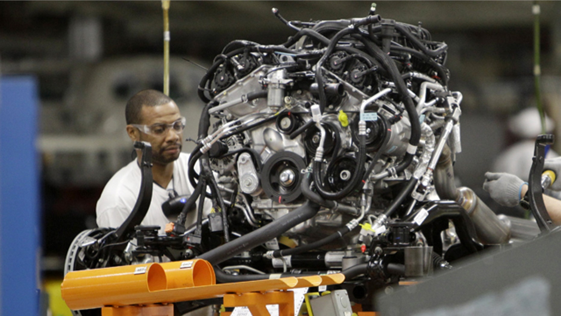 FILE - In this April 28, 2011 file photo, an assemblyman works on an engine for the Chrysler Jeep or the Dodge Durango which are built on the same line at Chrysler's Jefferson North Assembly Plant in Detroit. The company reported first-quarter net income of $116 million and revenues of $13.1 billion on Monday, May 2, 2011. The profit is a milestone in Chrysler's long road back to health after its 2009 bankruptcy. It last reported a profit in 2007. (AP Photo/Carlos Osorio)