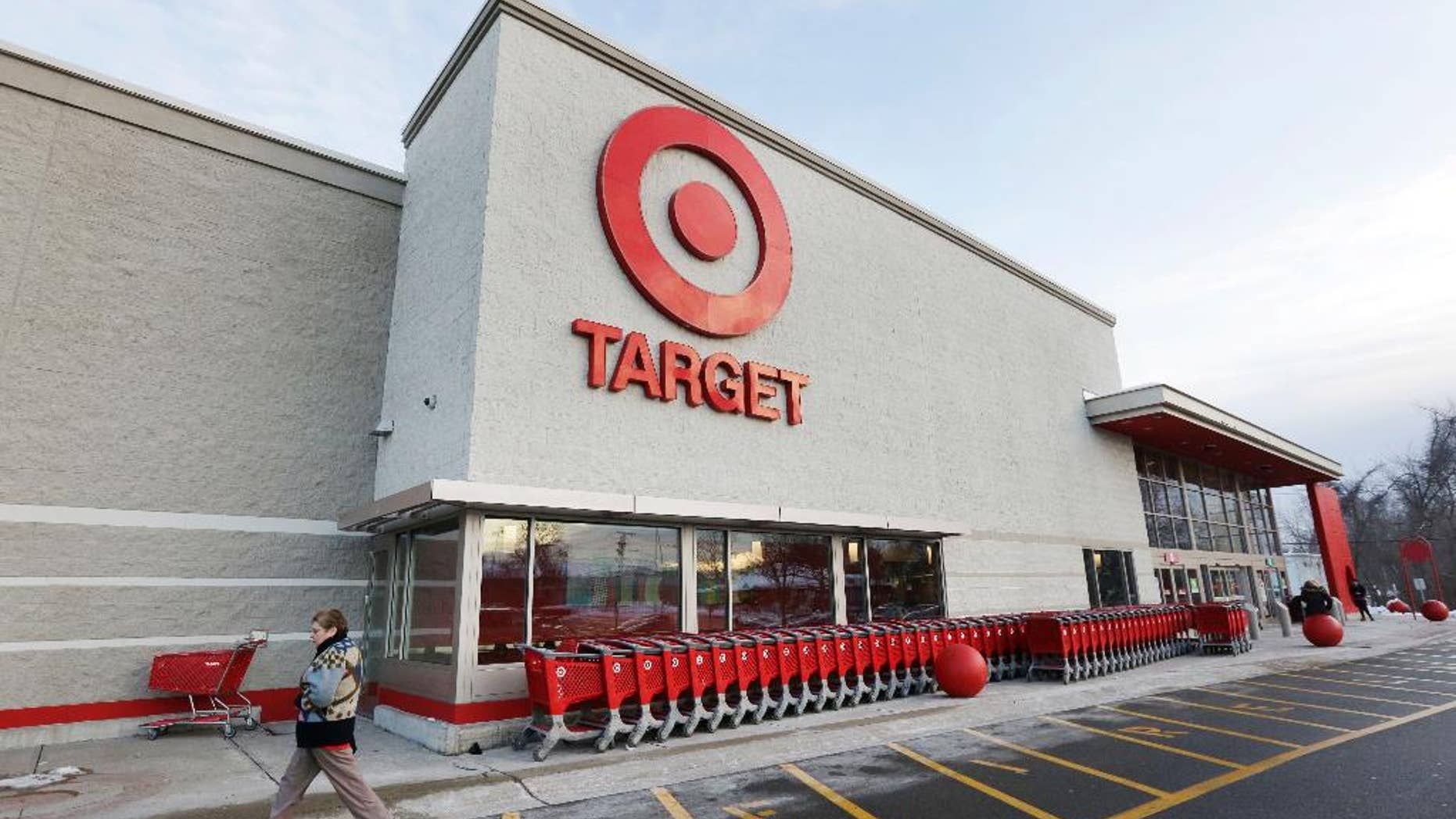 FILE - In this Dec. 19, 2013, file photo, a passer-by walks near an entrance to a Target retail store in Watertown, Mass. Target Corp. reports quarterly financial results before the market opens Wednesday, May 20, 2015. (AP Photo/Steven Senne, File)